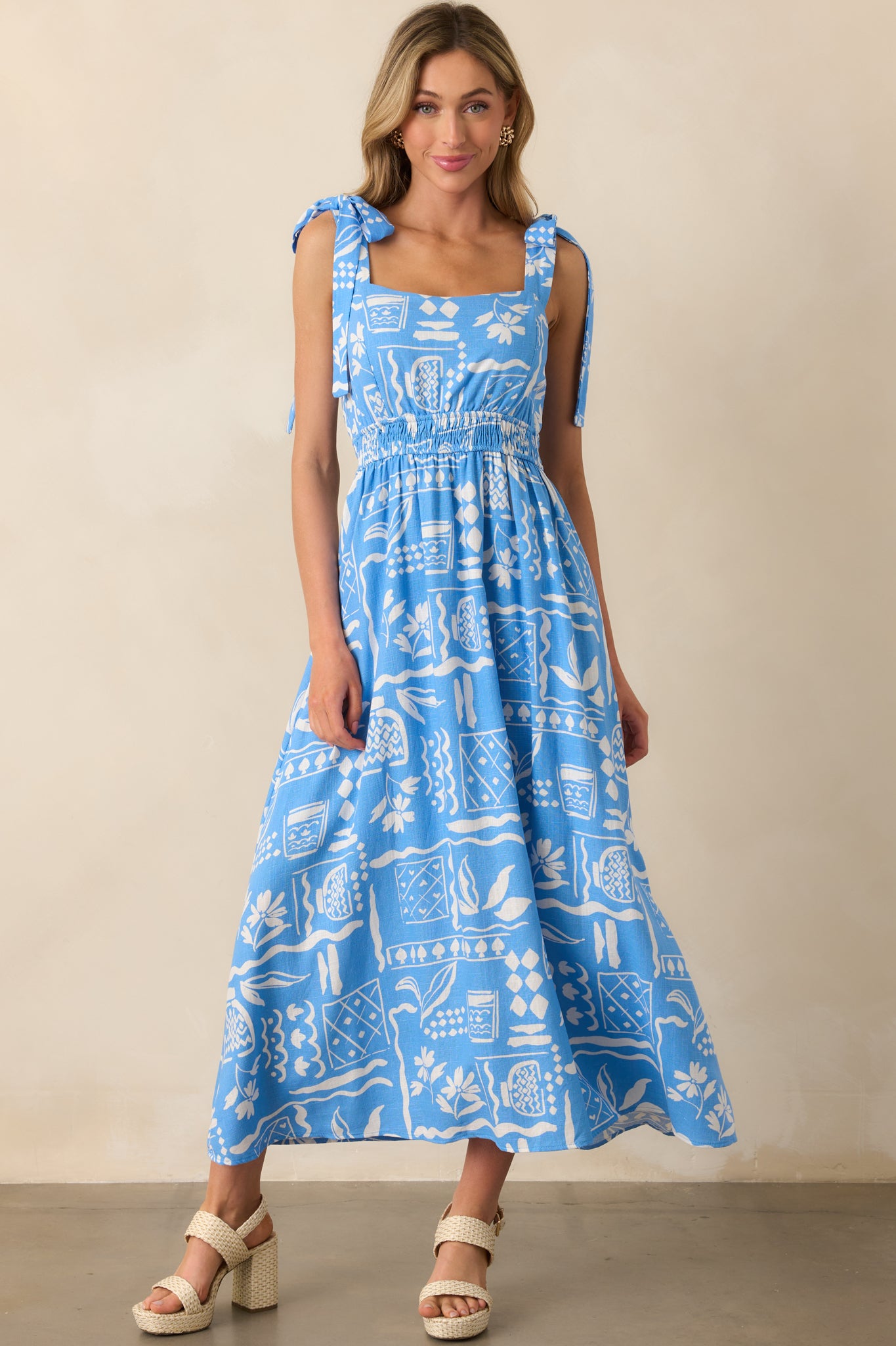 Full view of tropical printed dress showing the relaxed silhouette, decorative shoulder ties, and flowing skirt.
