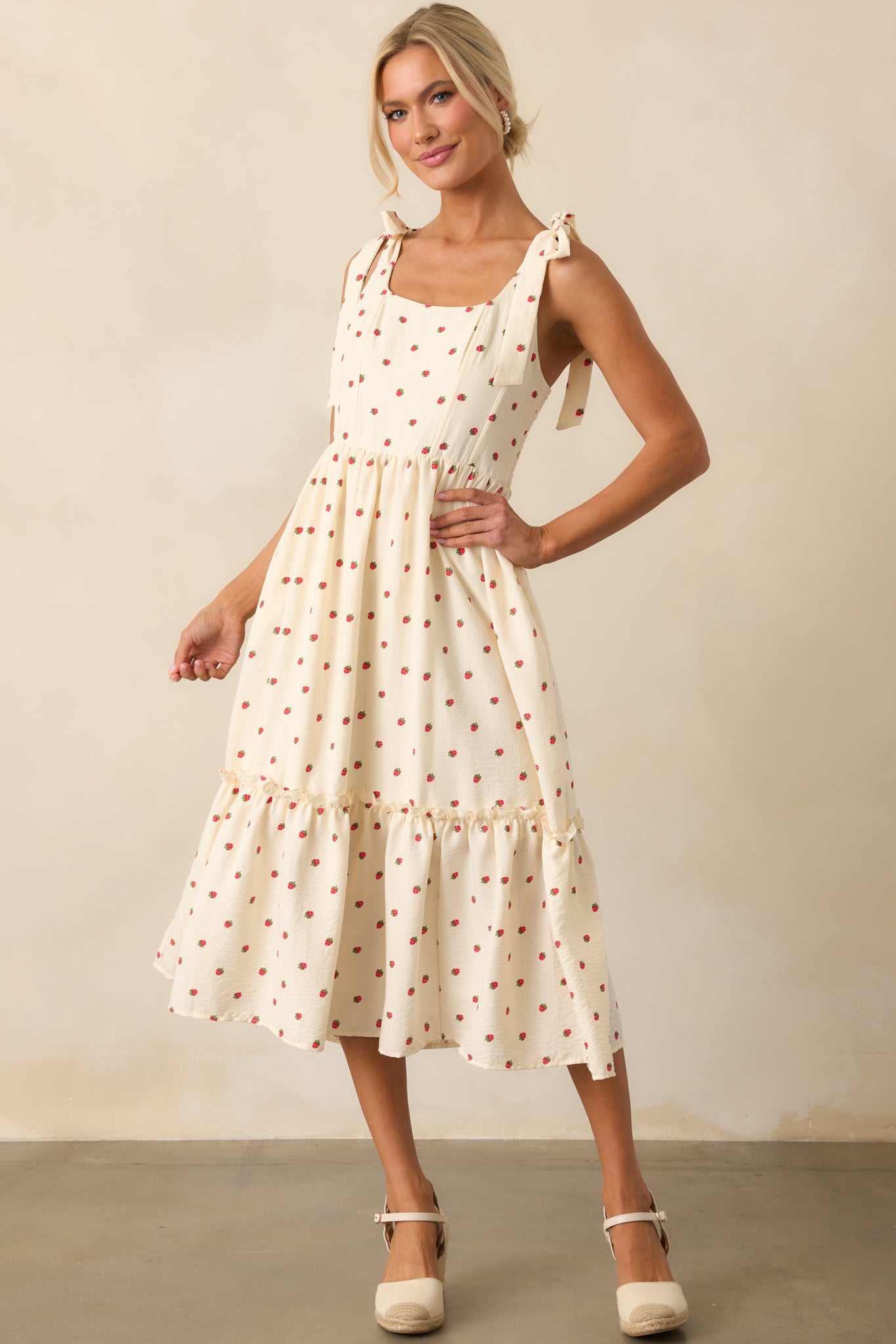 An angled front-facing shot highlighting the scoop neckline and delicate strawberry pattern throughout the ivory dress.