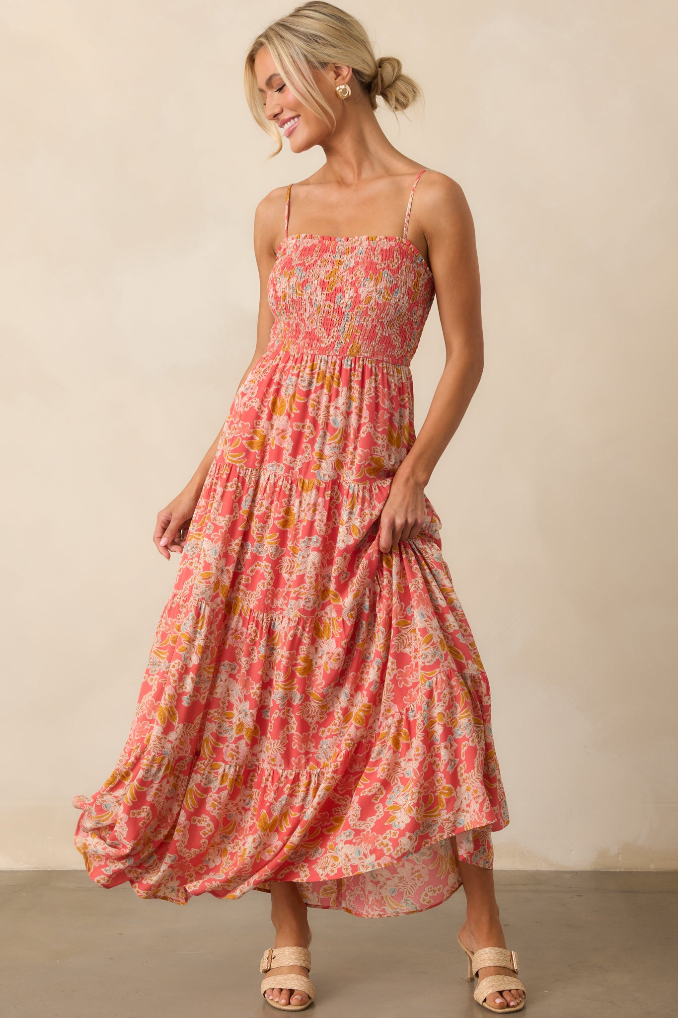 Pink coral dress shown from the front, highlighting the smocked bust and flowy tiered skirt.