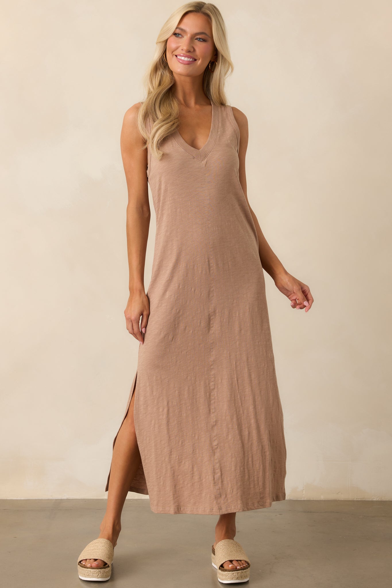 Tan iced coffee dress with a v-neckline and sleeveless design, shown in a full body front view with a relaxed fit and side leg slits.