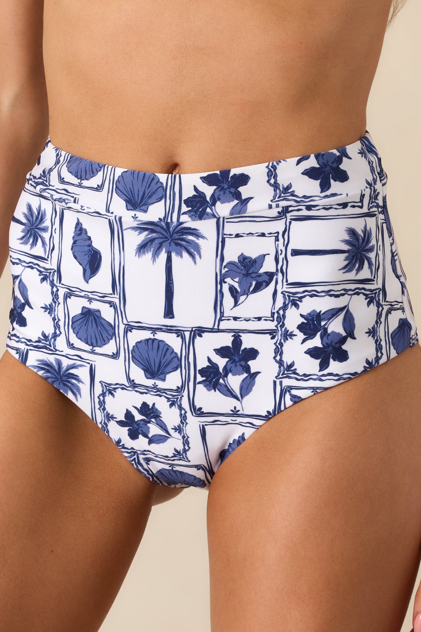 Close-up of fabric texture displaying blue patchwork beach motif and stitching details.