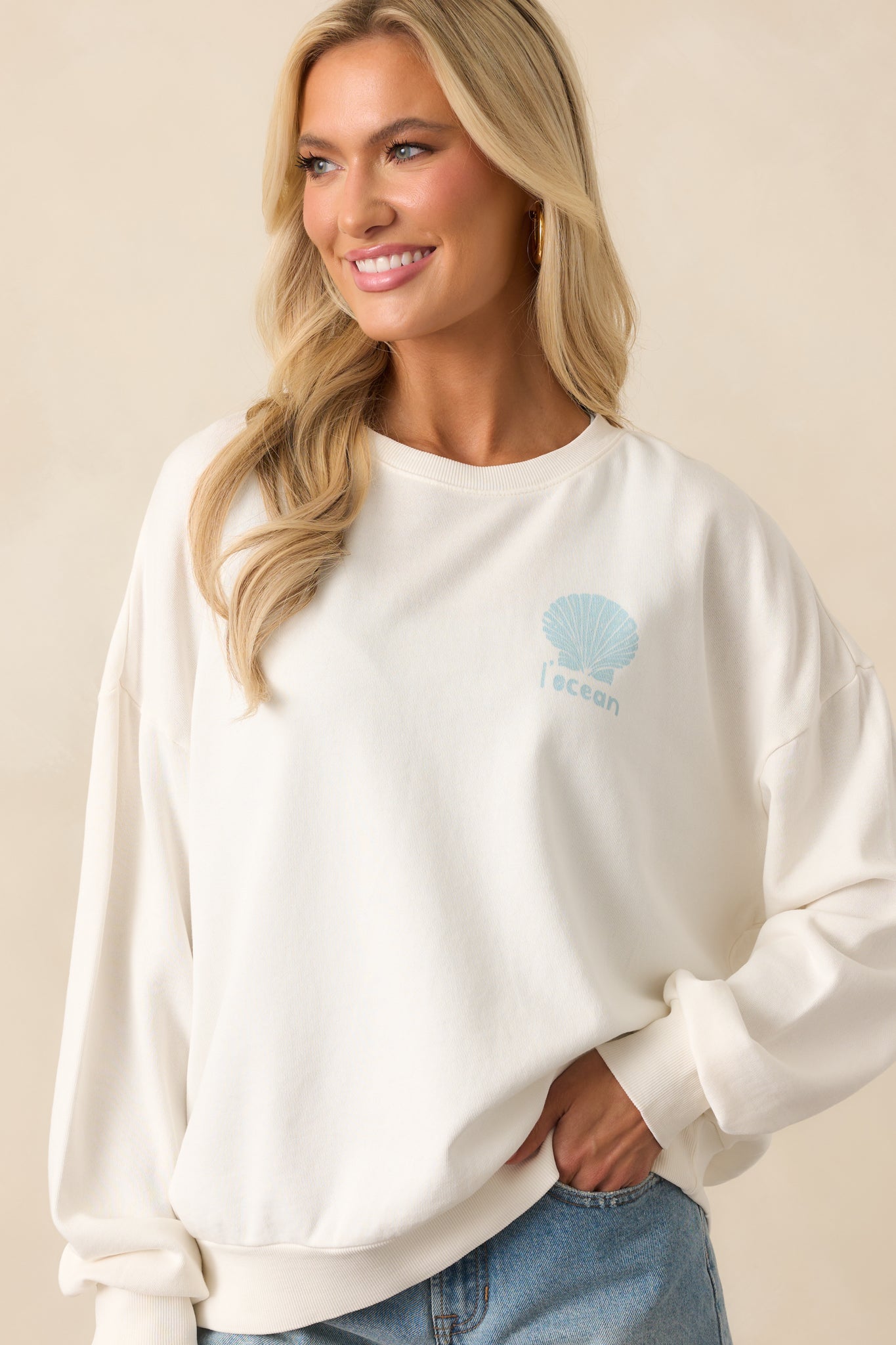 Focused view of the sweatshirt’s front hem and sleeve detail, highlighting the relaxed drape and soft material