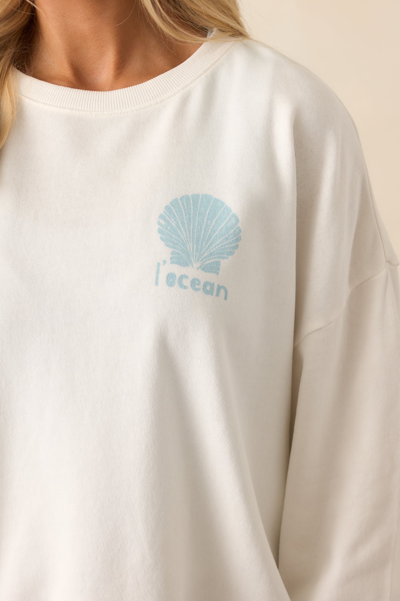 Detailed close-up of the large ocean-inspired graphic on the back of the sweatshirt, showing fine print texture and coastal design elements.