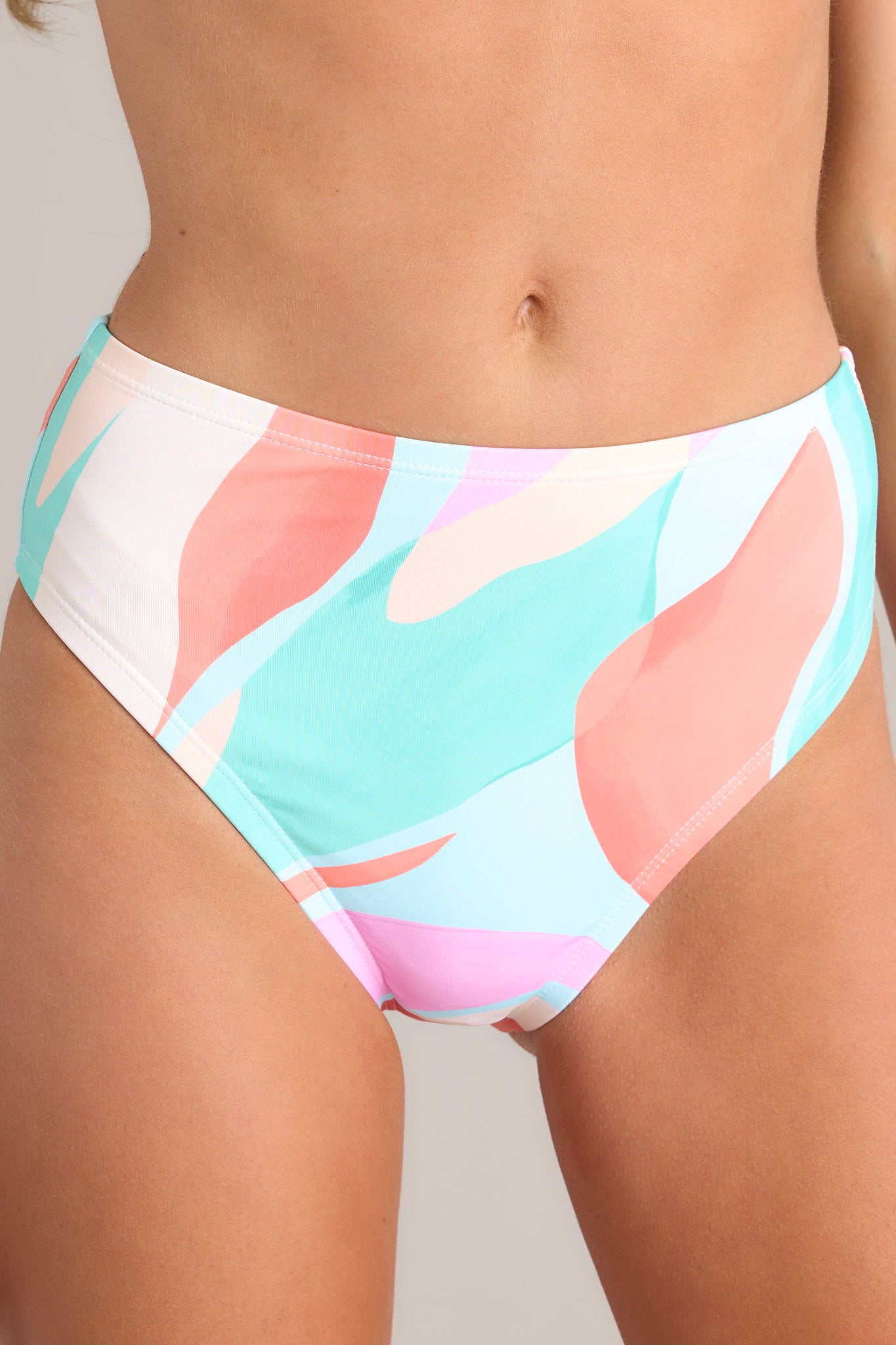 These multi-colored bikini bottoms feature a high waisted design, an elastic waistband, a high cut, and a slightly cheeky backside.