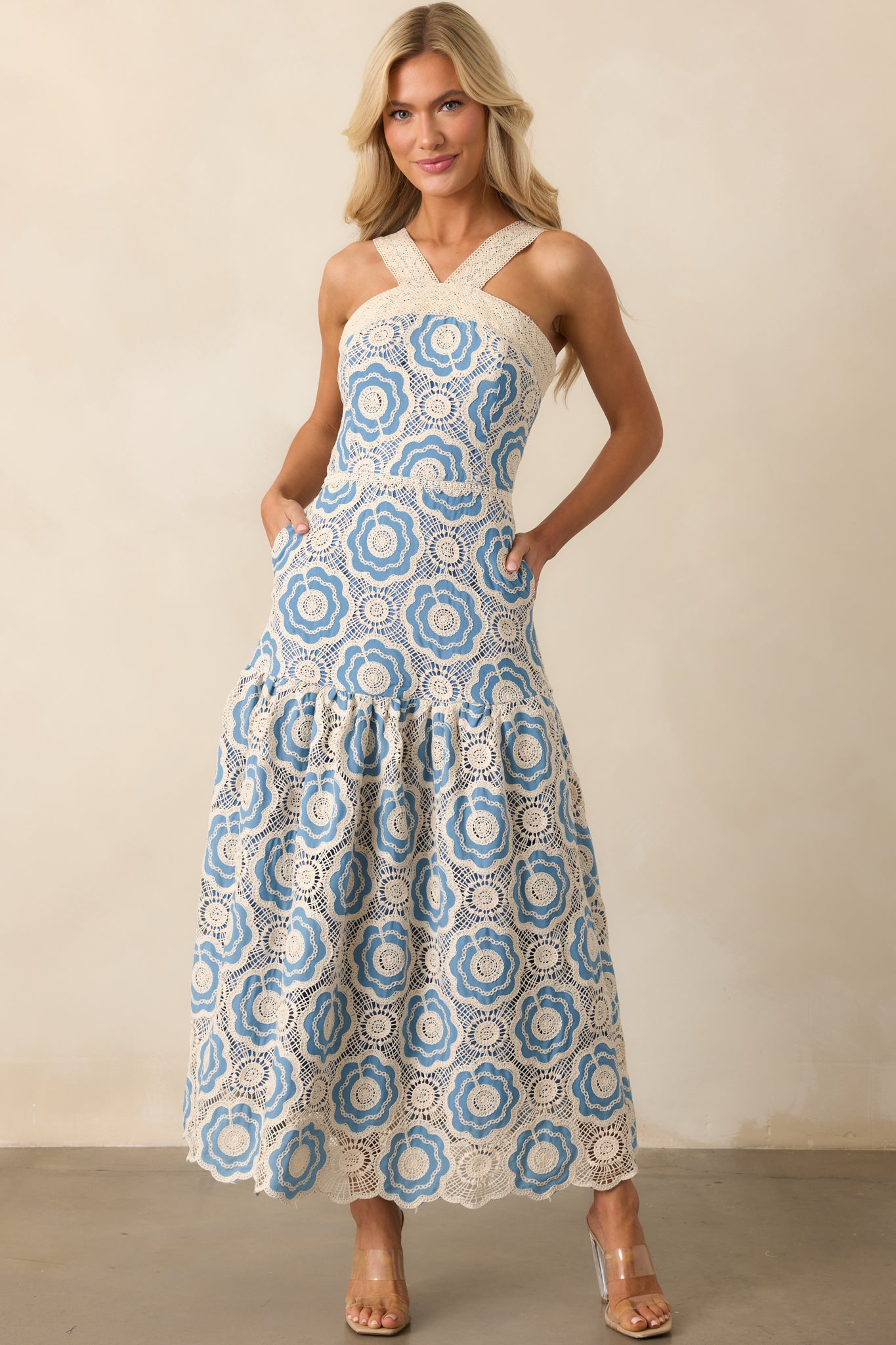 Detailed view of the light blue dress showing the embroidered eyelet pattern across the full length.