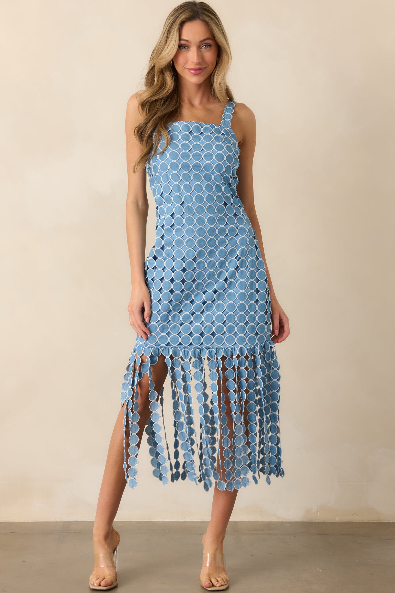 Full view of blue dress emphasizing the textured fringe hem and clean, structured lines.
