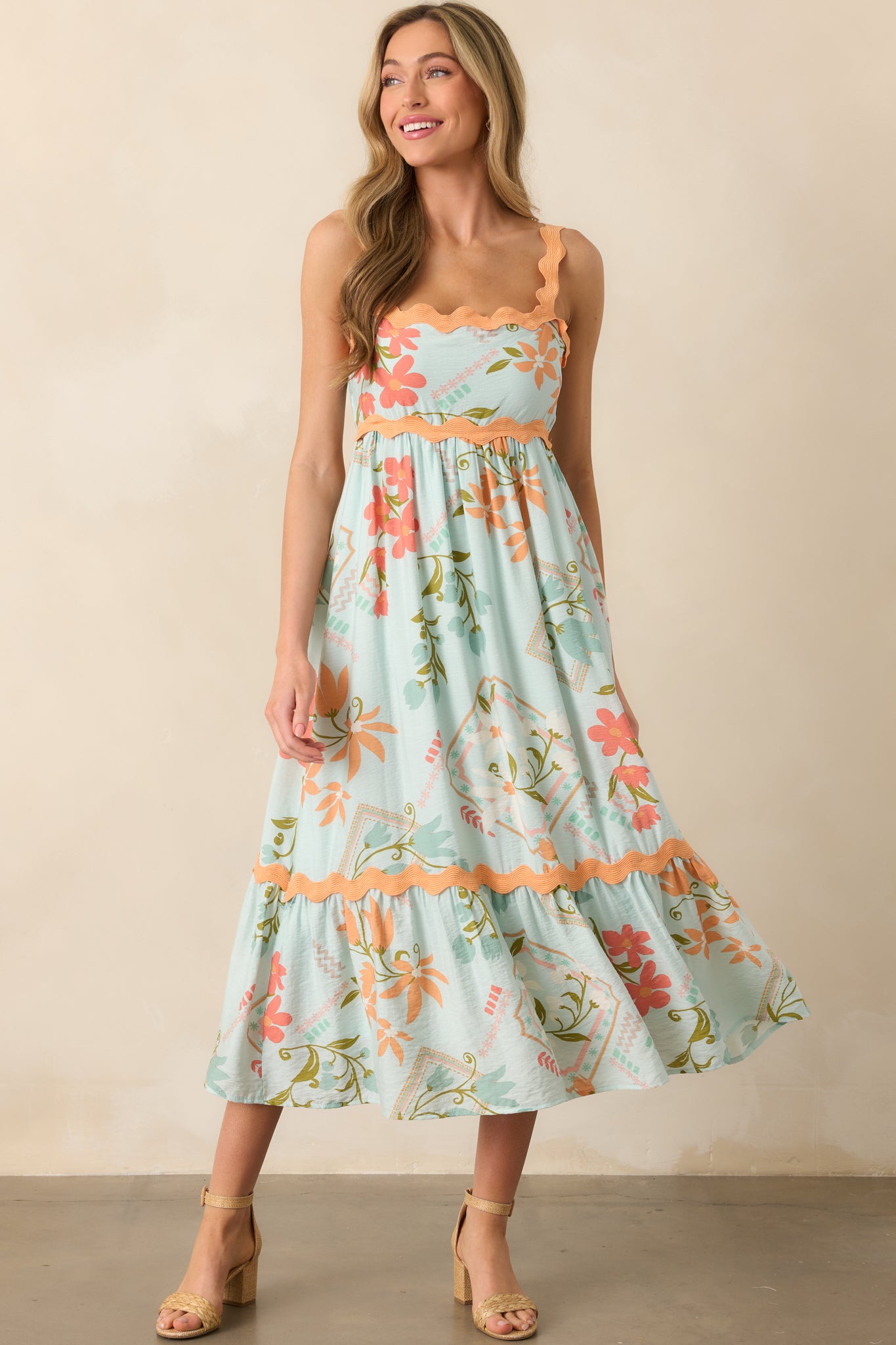 Mint green maxi dress with multicolor patchwork floral print, shown from the front with square neckline and orange ric rac trim highlighting the bodice and tiered hem.