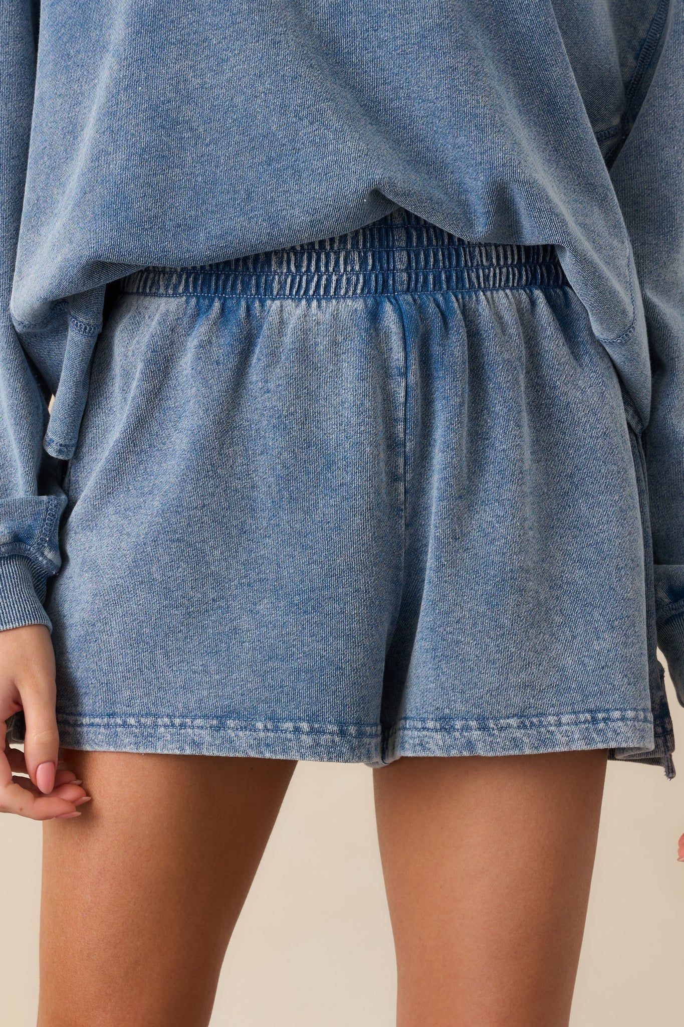 A detailed image of the elastic waistband and side seam stitching on the high-rise shorts, showing texture and construction.