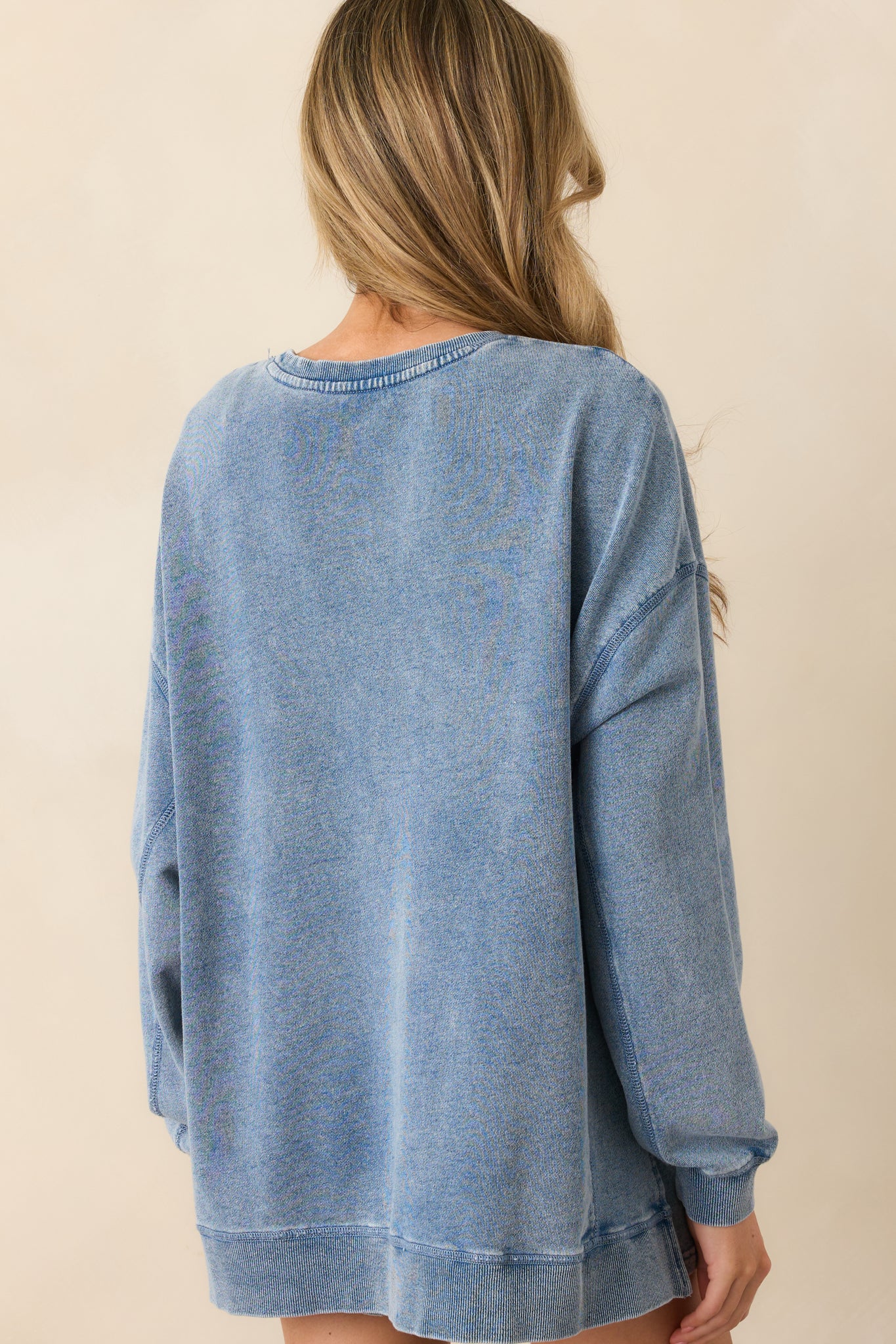 A view from behind of the sweatshirt, emphasizing the relaxed drape and shoulder seam construction.