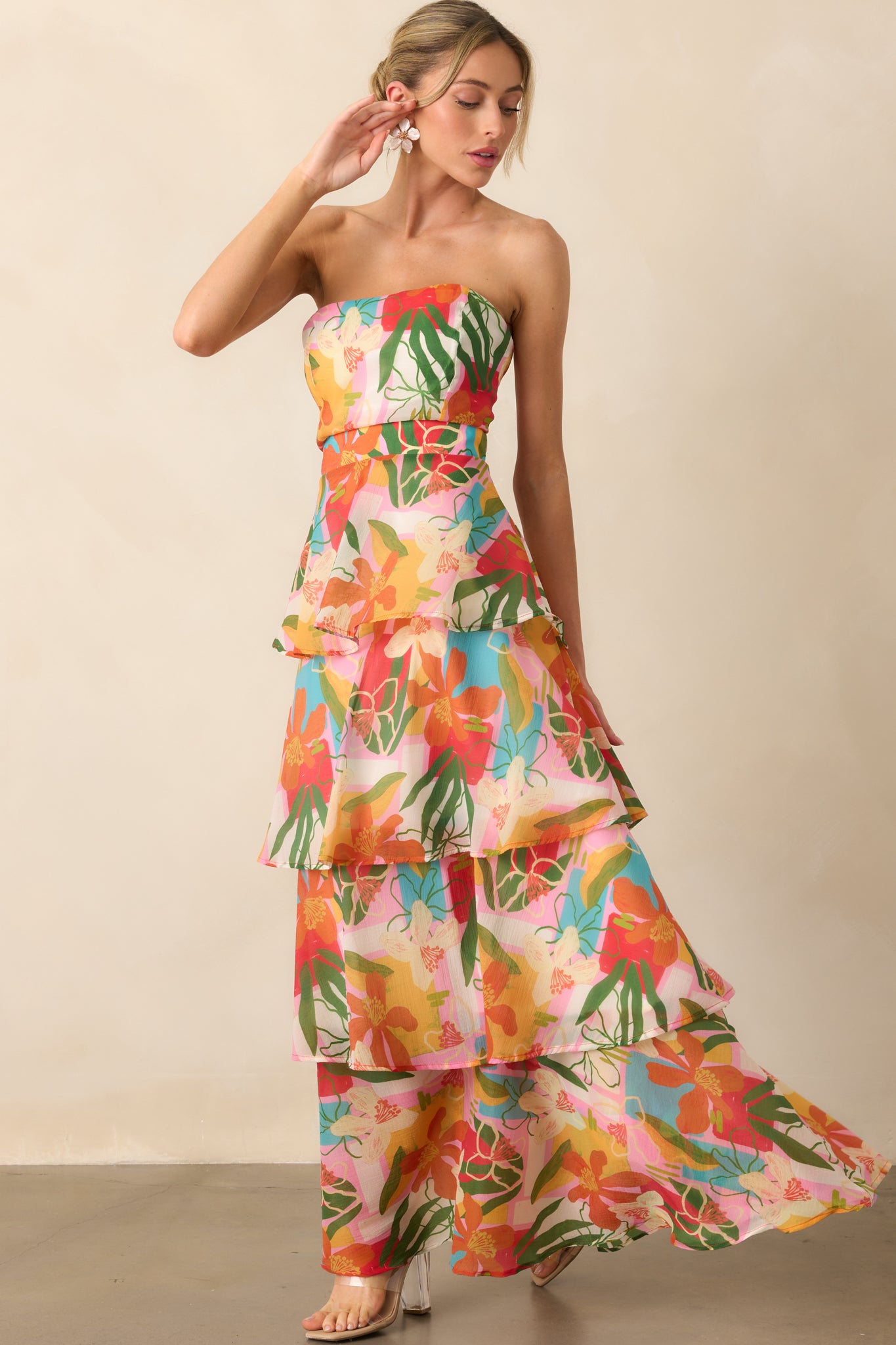 Full-length look at the strapless dress highlighting its bright tropical print and breezy silhouette.