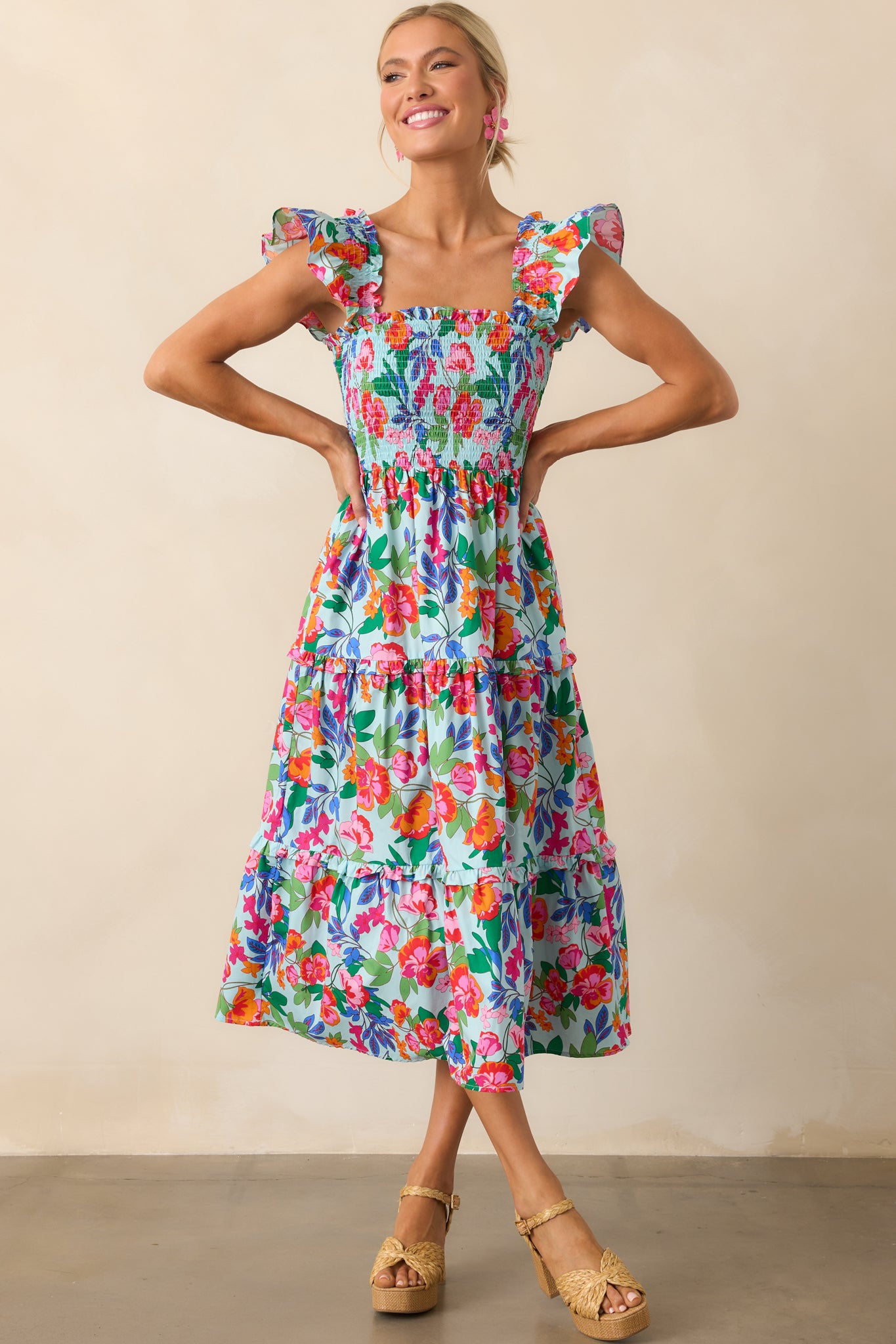 Front view of a smocked light blue dress highlighting the ruffle trim details along the sleeves and skirt.