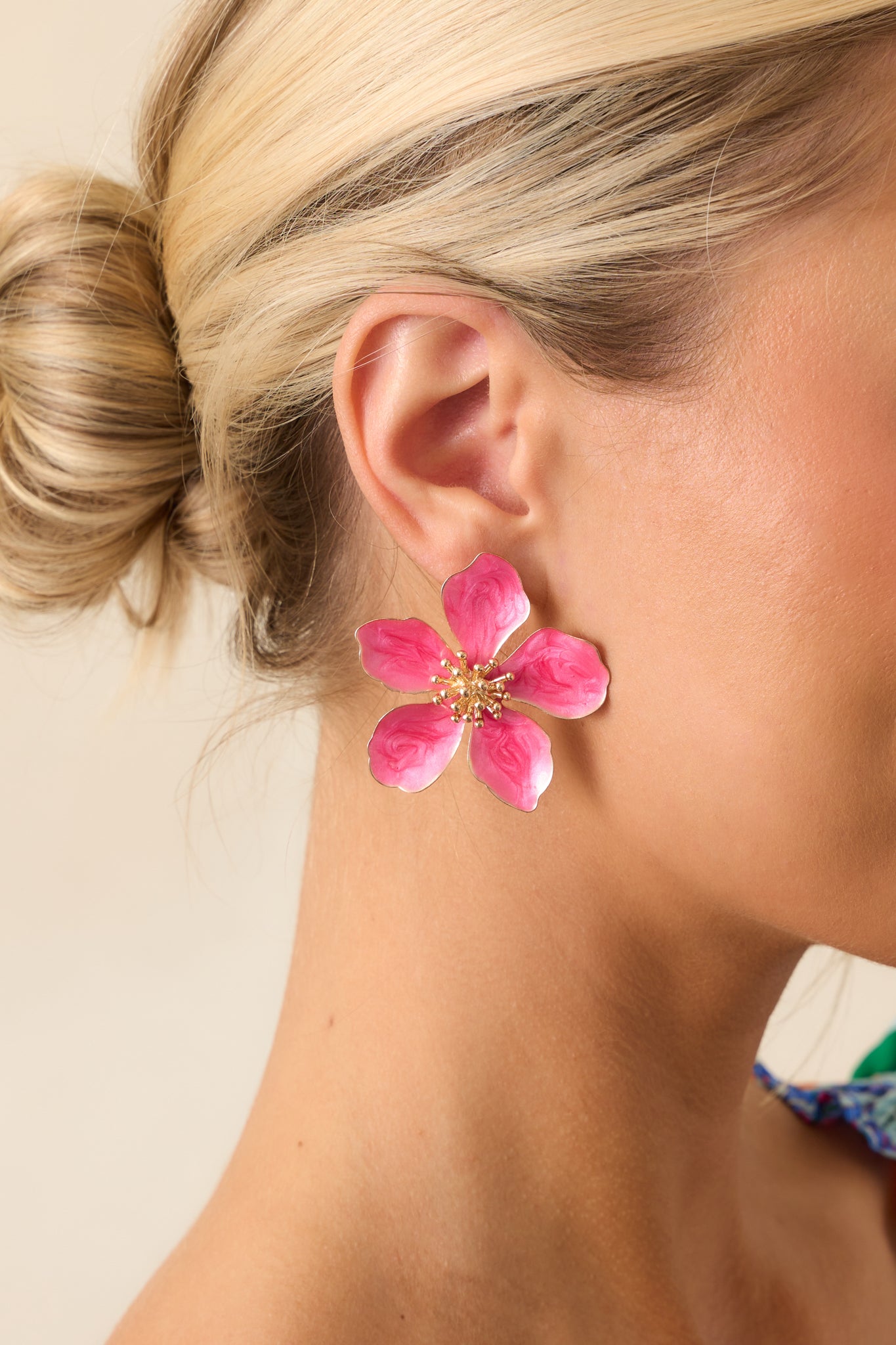 A pair of fuchsia flower earrings with a stud design, featuring five pointed pearlescent petals and gold hardware.