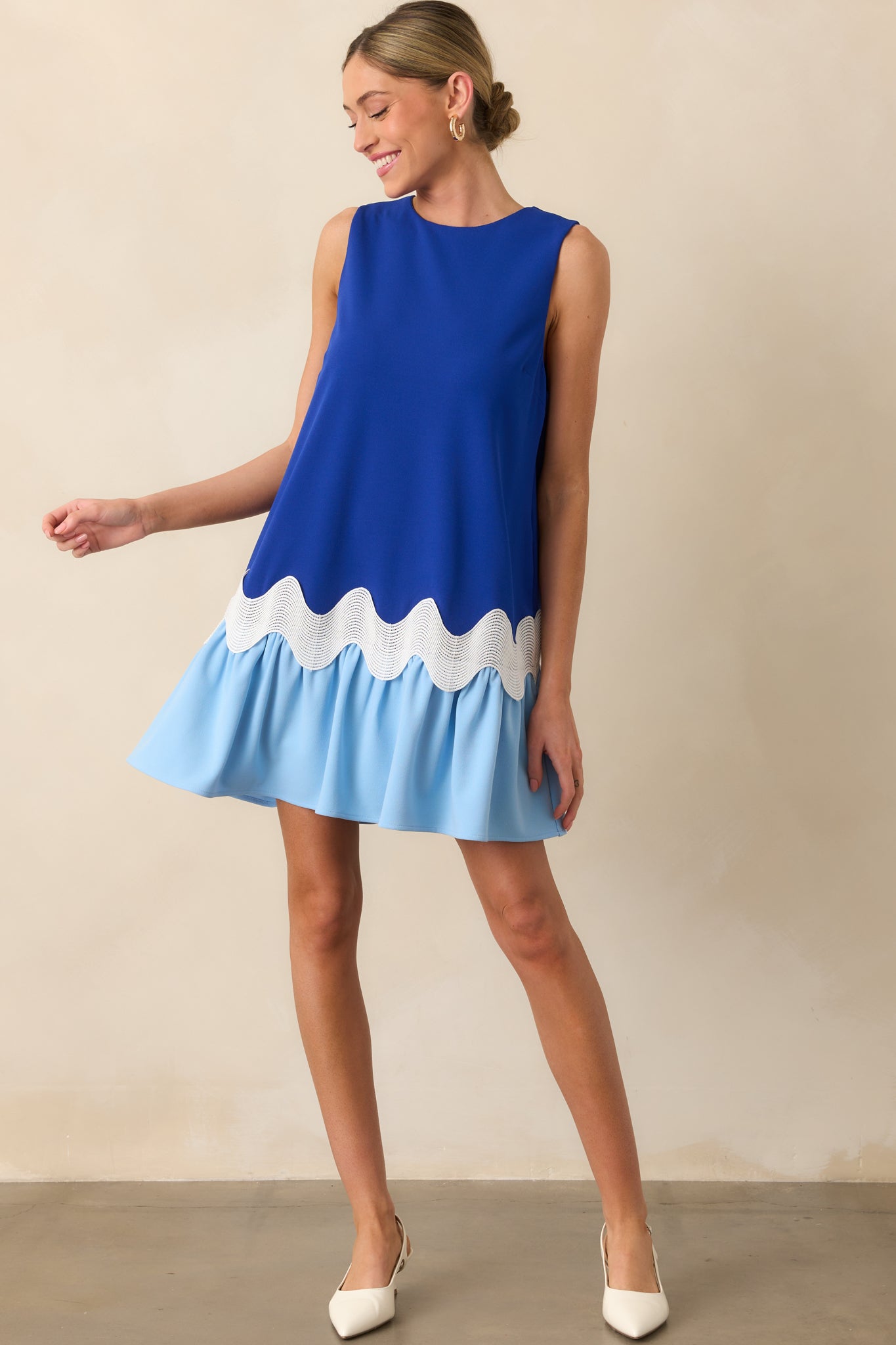 Full-length angled shot of the dress highlighting the contrast between the upper blue bodice and the lighter blue lower portion, along with side pockets.