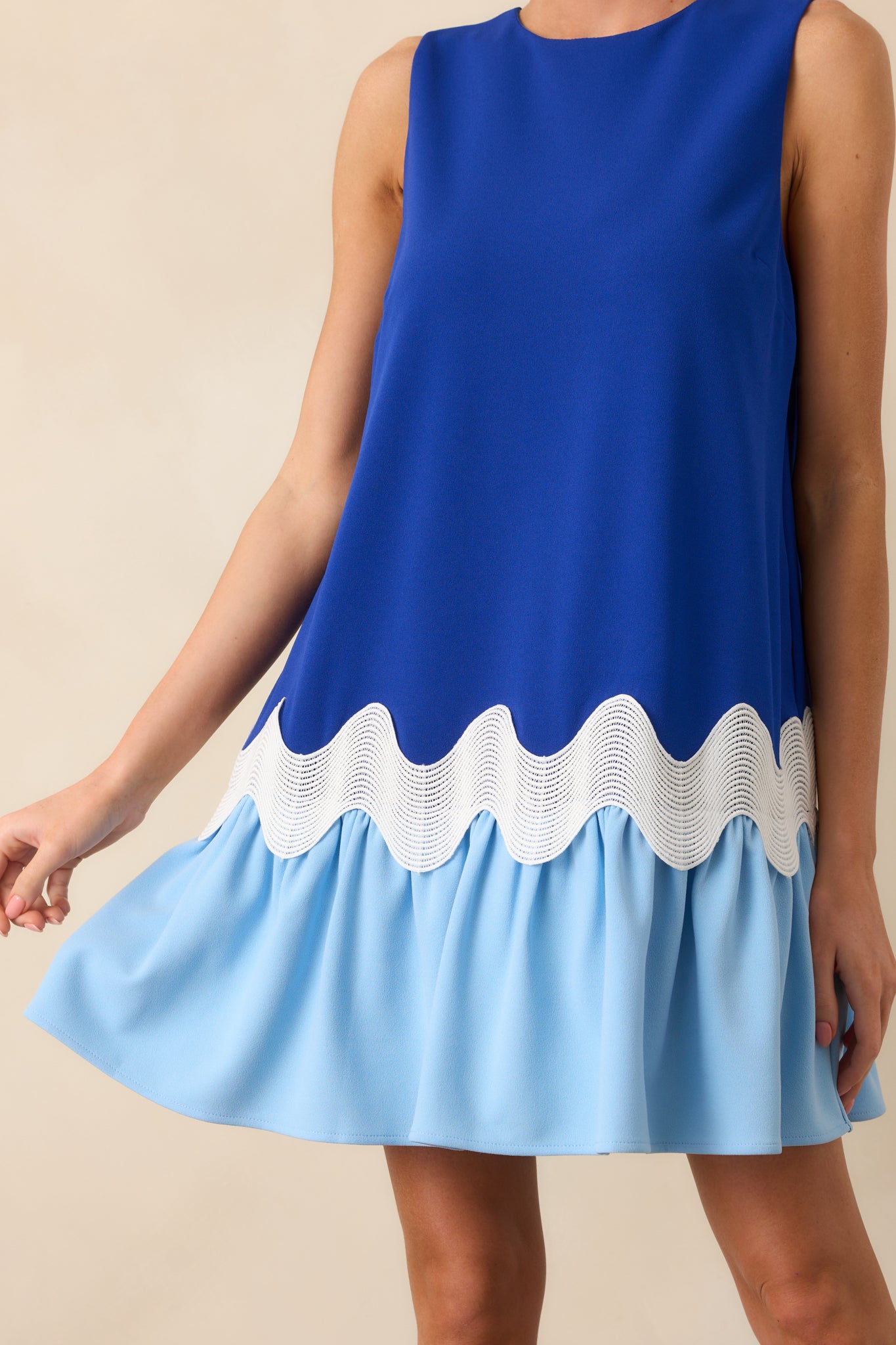 Close-up of the white ric rac trim across the blue fabric, showing the texture and stitching of the design.