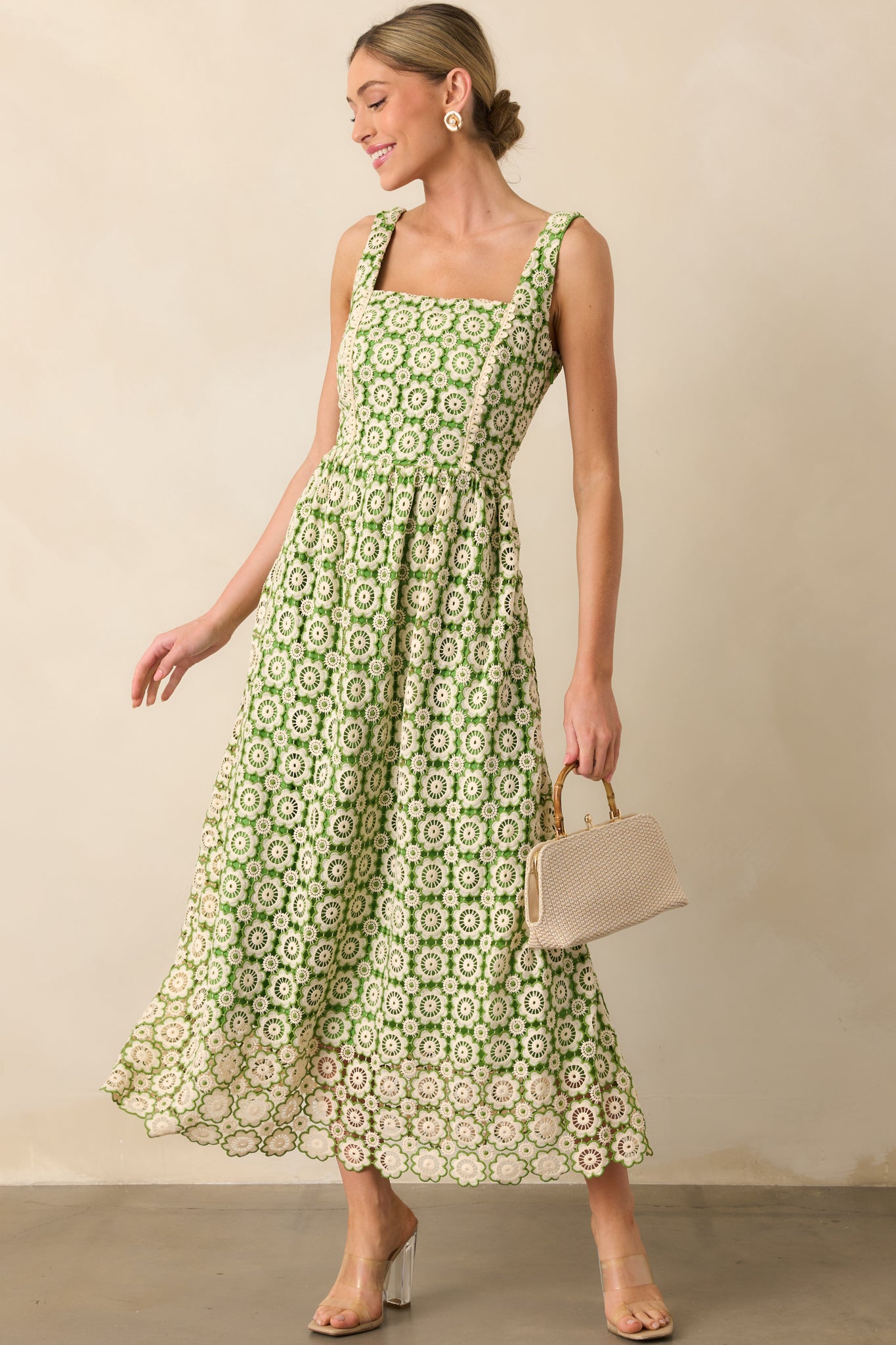 Green dress with self-tie green bow in the back, functional side pockets, and a floral embroidered overlay in beige and green.