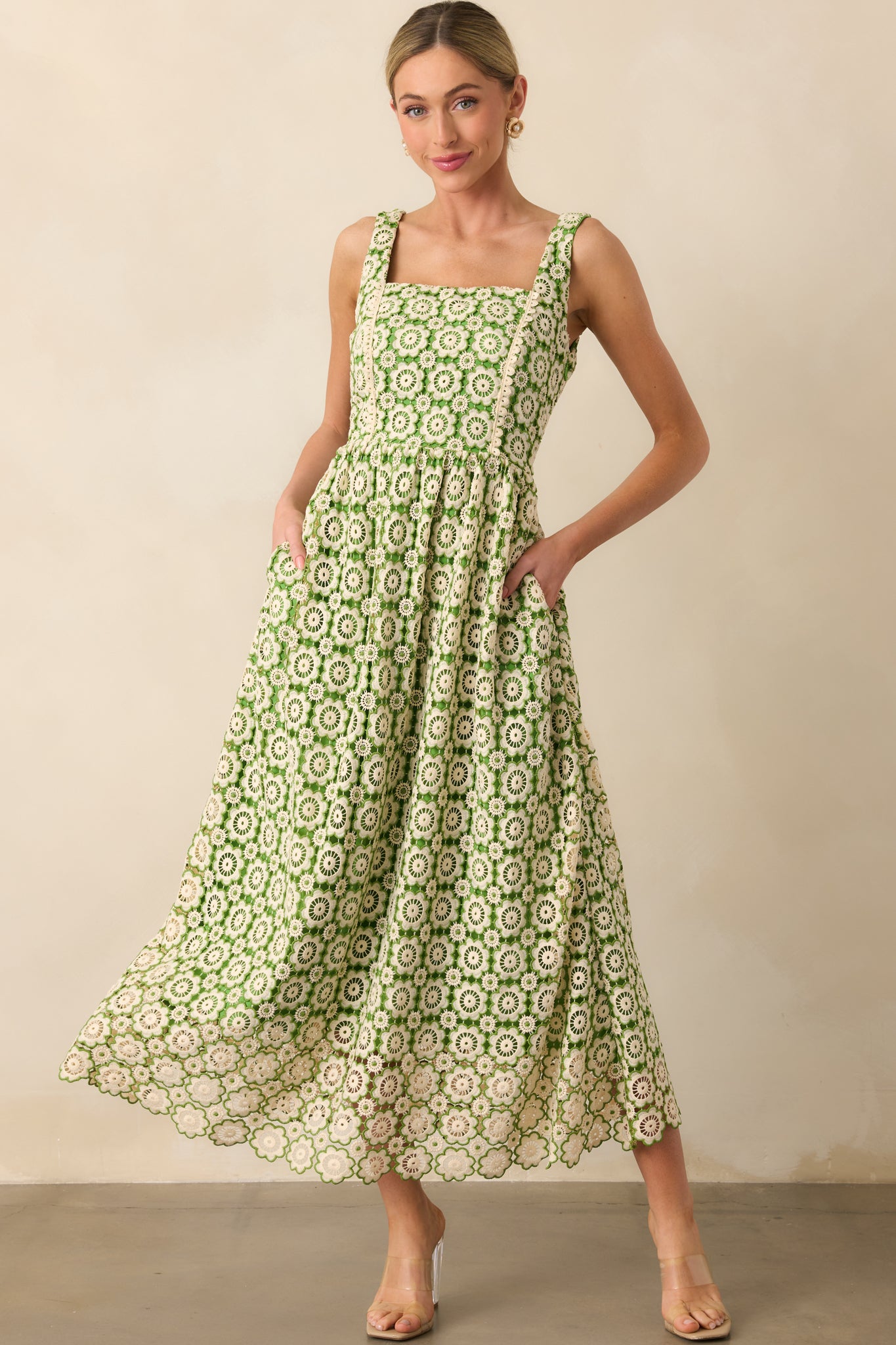 Dress with beige scallop detailing and a rich green lining, accentuated by delicate floral embroidery in beige and green.