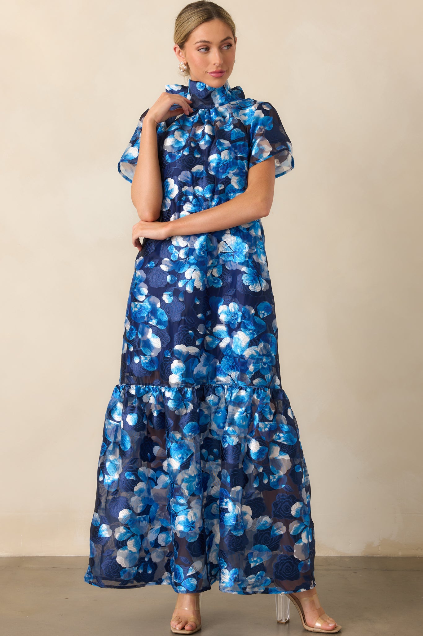 Frontal angle showing the dress's elegant high neck and soft silhouette with a layered skirt.