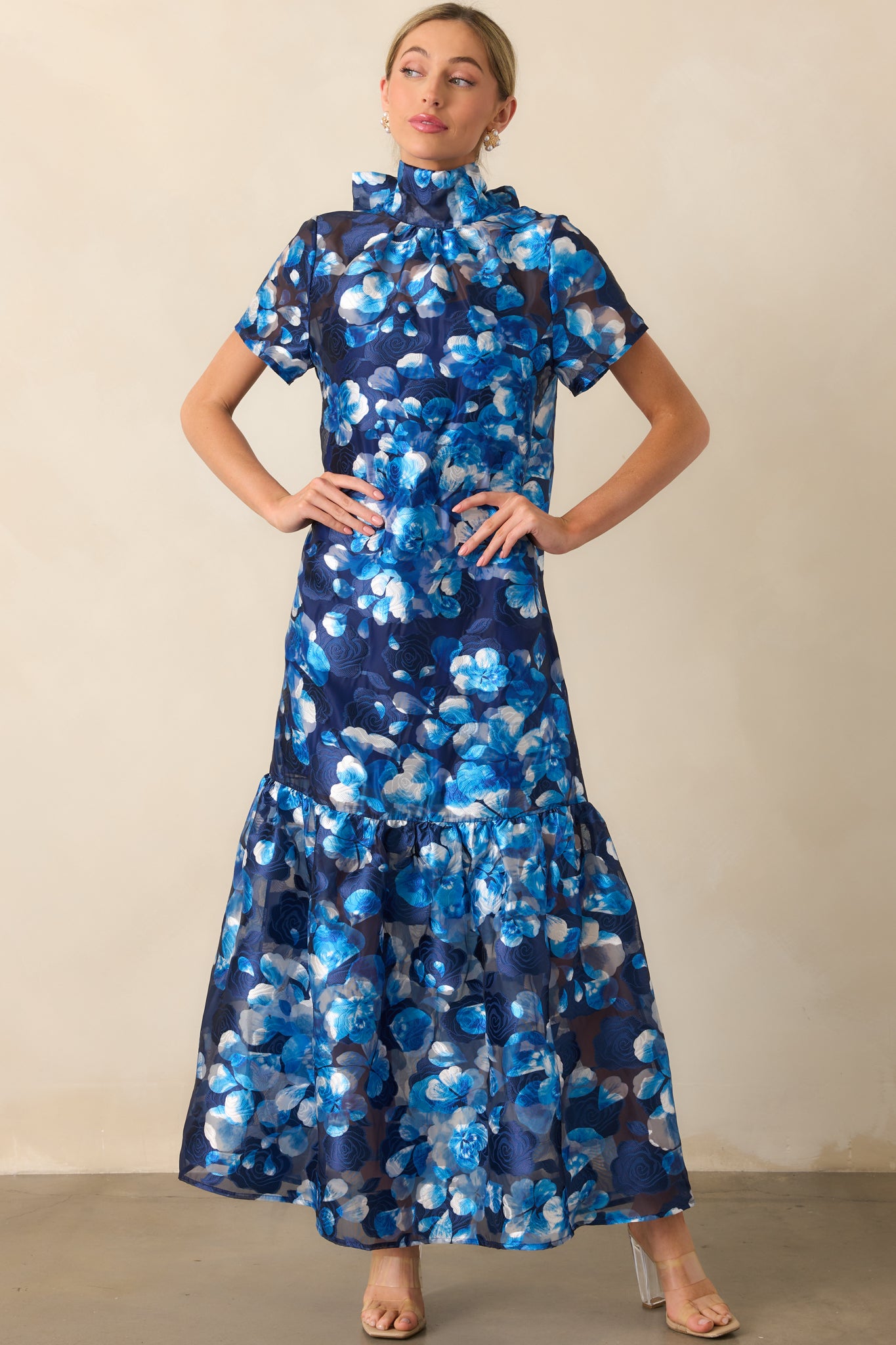 Complete view of the dress with a focus on its delicate floral print and gently structured tiers.