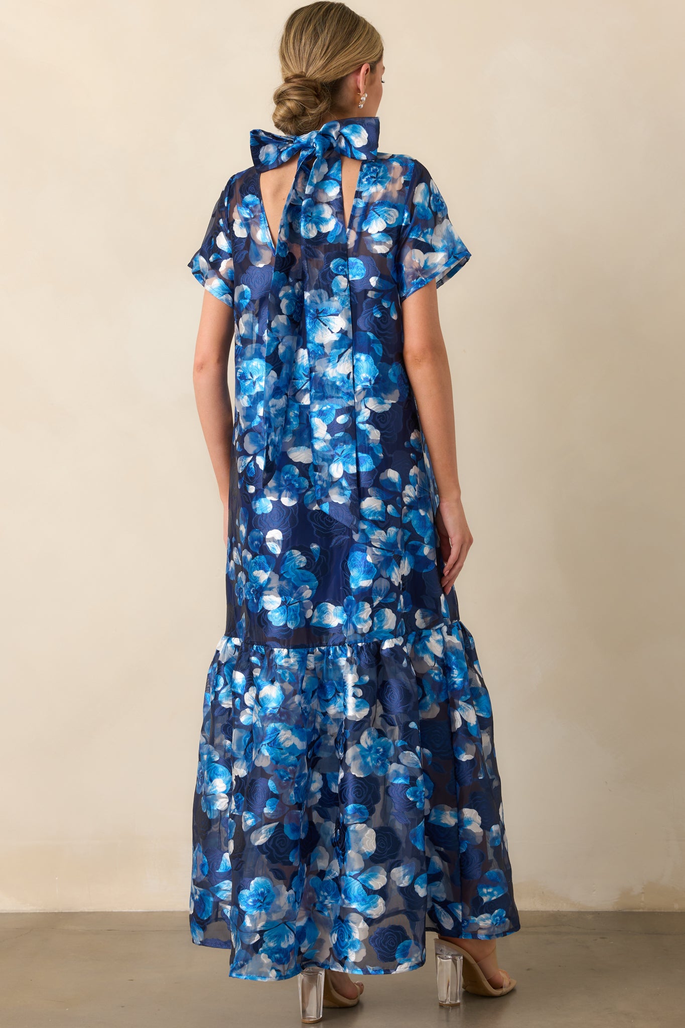 A view from behind showing the self-tie bow at the neckline and the sheer overlay.