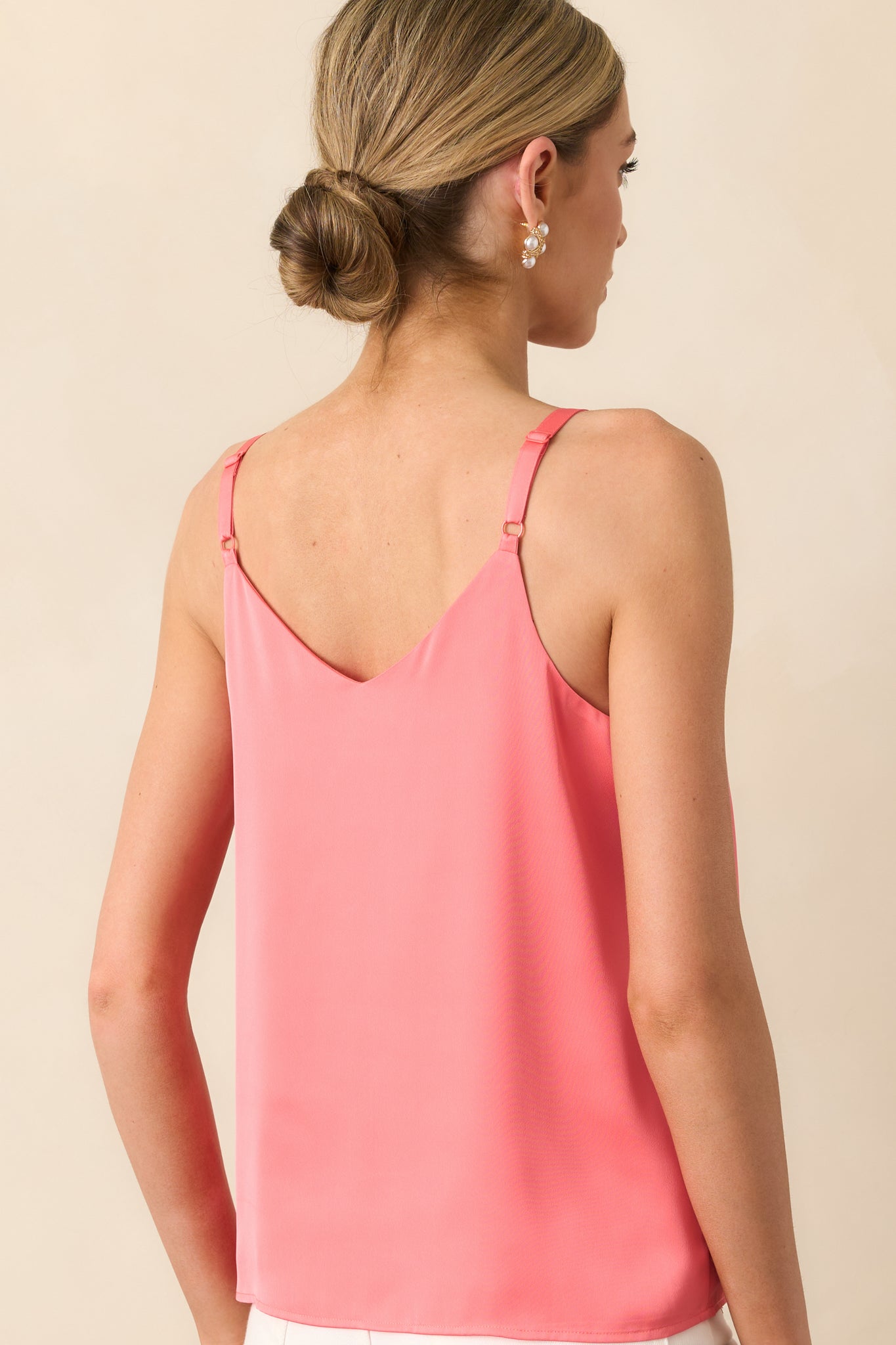 Rear view of coral top featuring adjustable double straps and clean, flowy back in satin fabric.