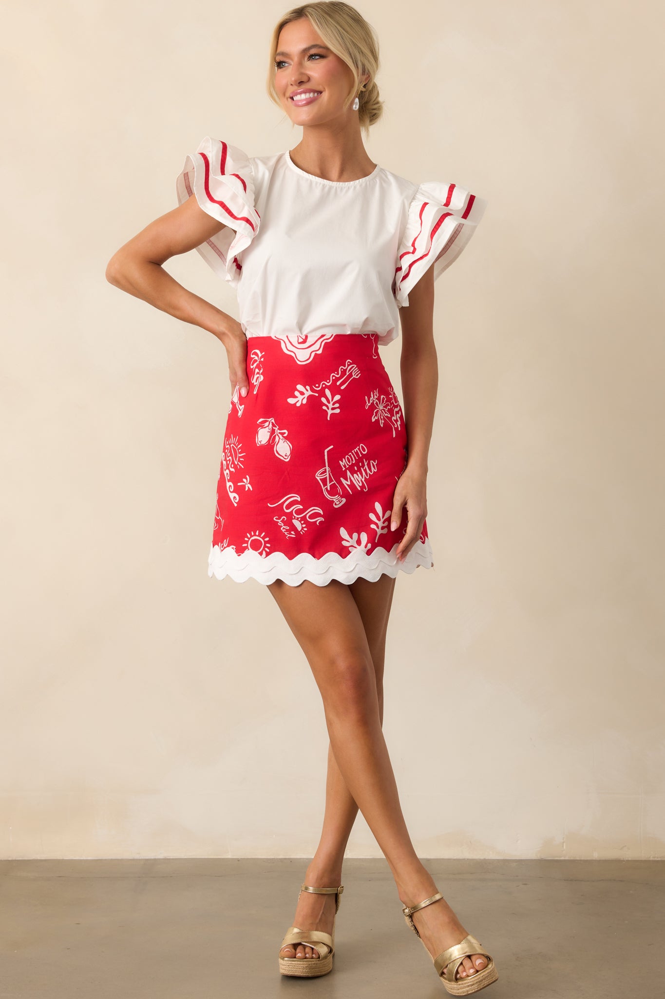 A full-length view of the white top, showcasing how the dramatic flutter sleeves frame the silhouette and add volume.