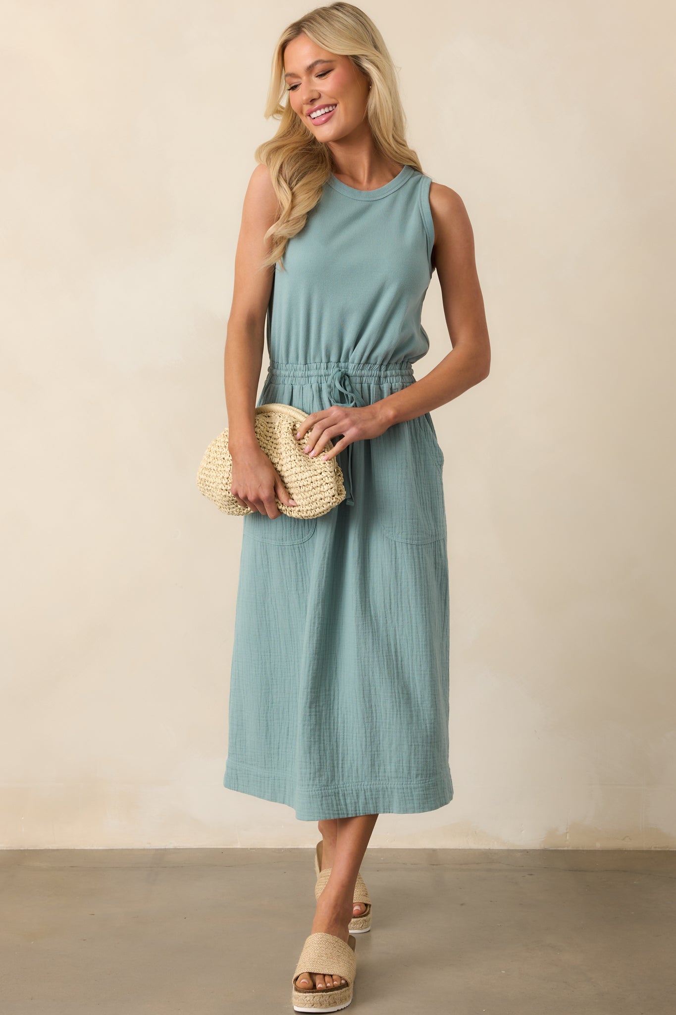 Sage midi dress with a round neckline and ribbed sleeveless bodice, shown in a full body front view.