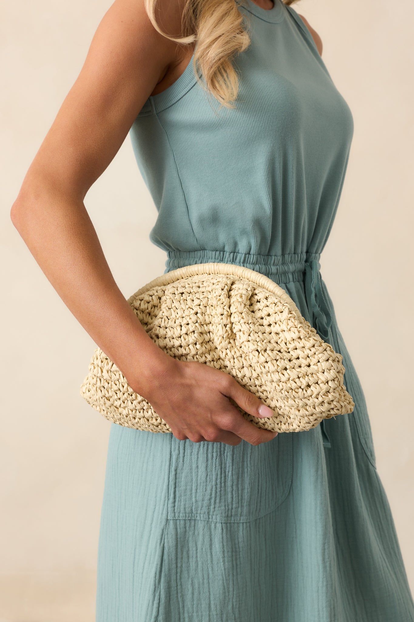 Cropped view focusing on the ruched texture of the ivory raffia material and the bag’s soft, slouchy structure.