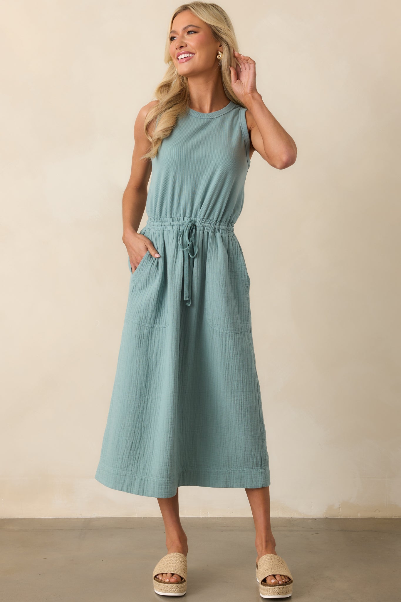 Sage dress displayed in a full length shot, showing the relaxed silhouette and soft textured skirt.