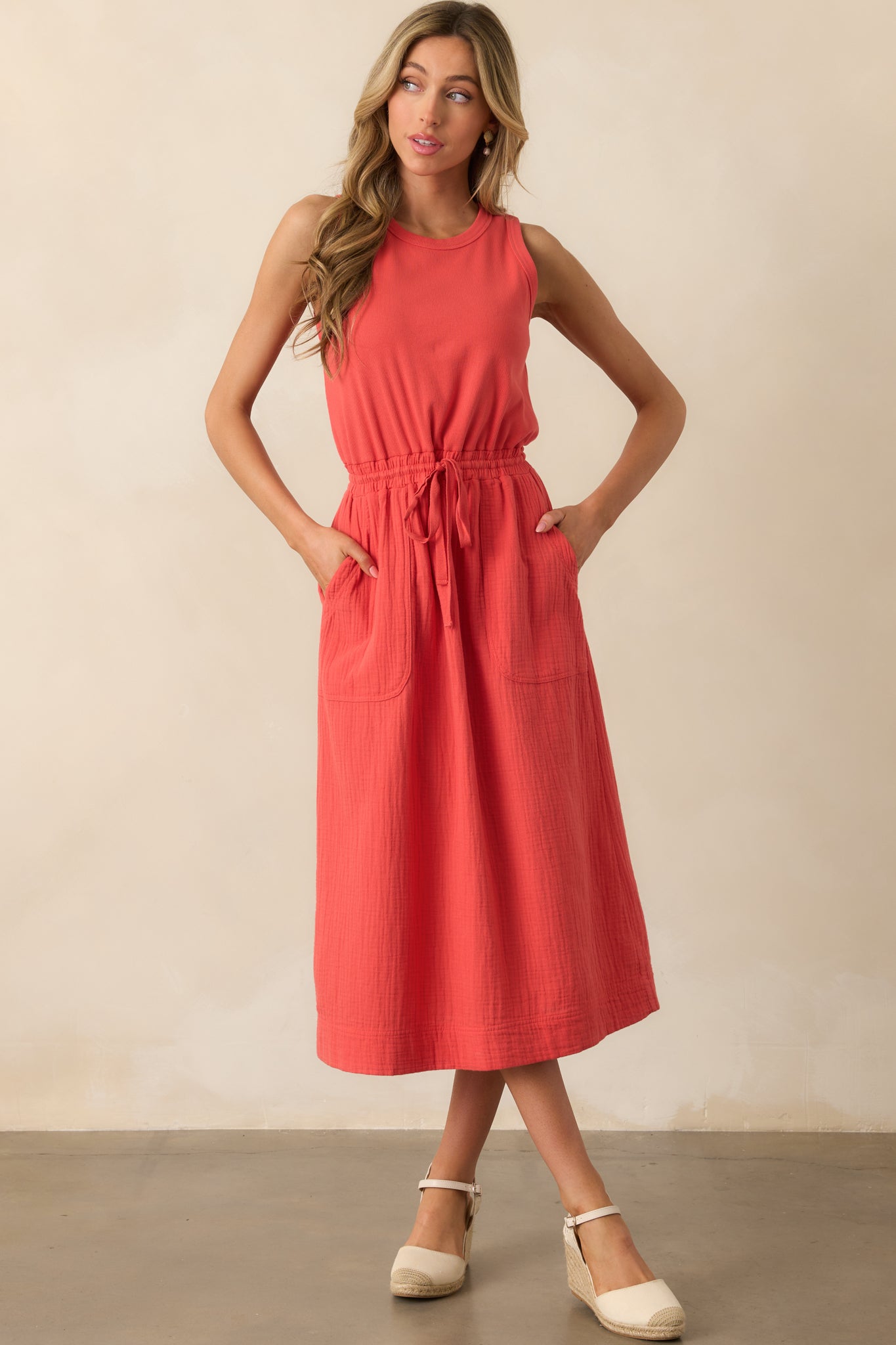 Full view of the red dress emphasizing the functional patch pockets and airy flow of the midi-length skirt.