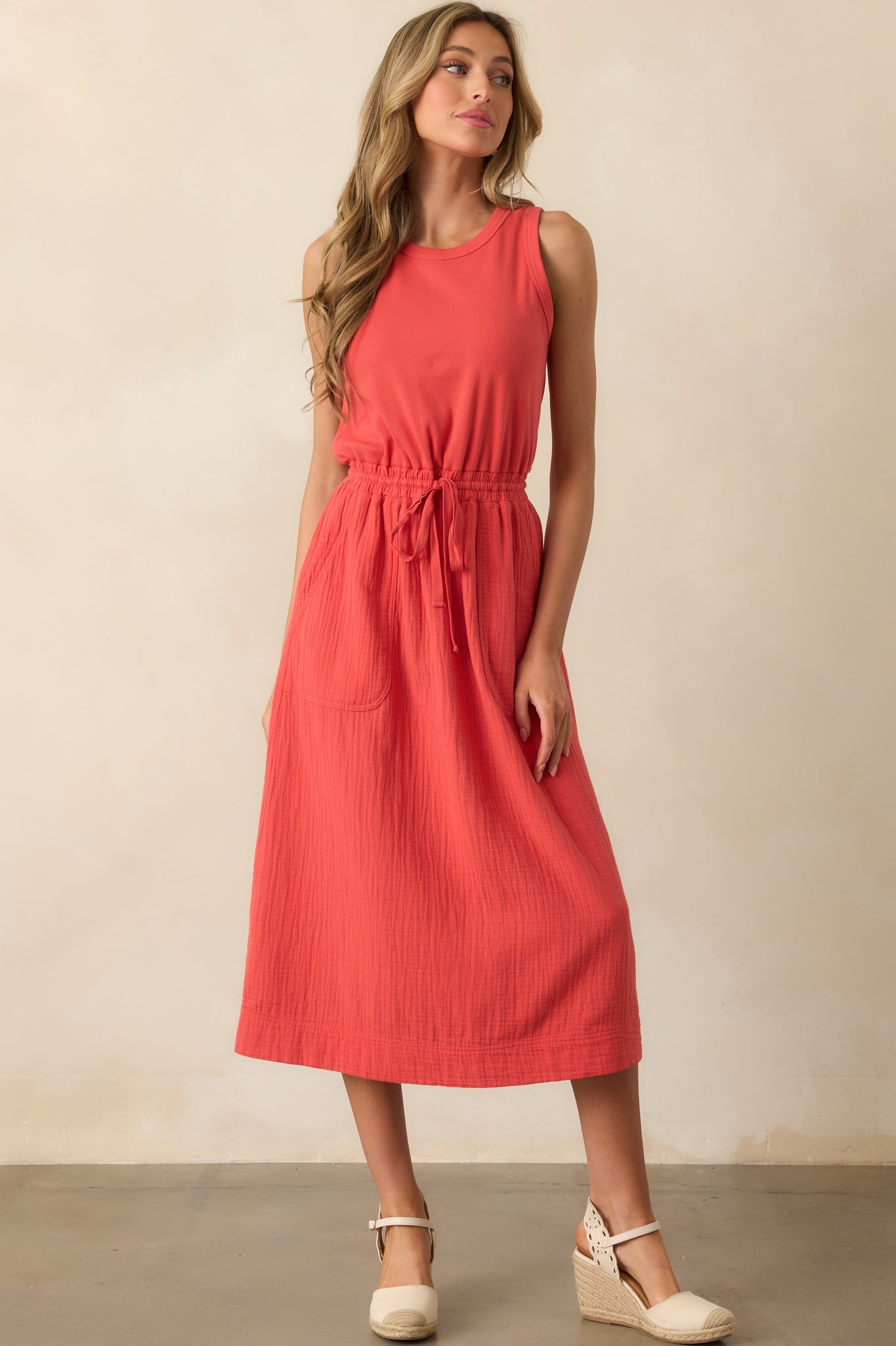 Straight-on full body image showing the sleeveless design and structured fit of the ribbed bodice with a soft drape in the skirt.