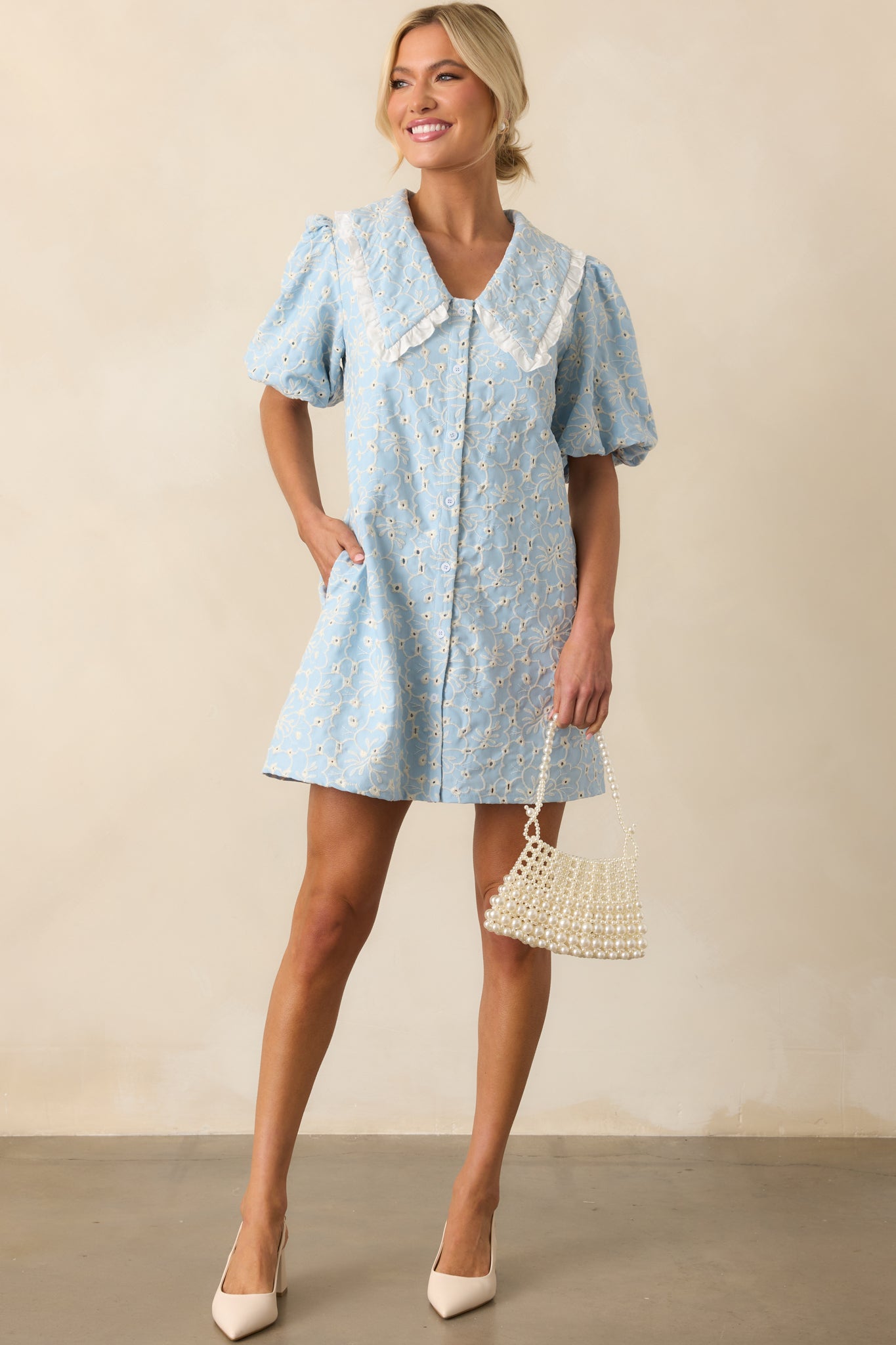 Light blue dress displayed from the front, highlighting ivory ruffle trim and tiered silhouette.