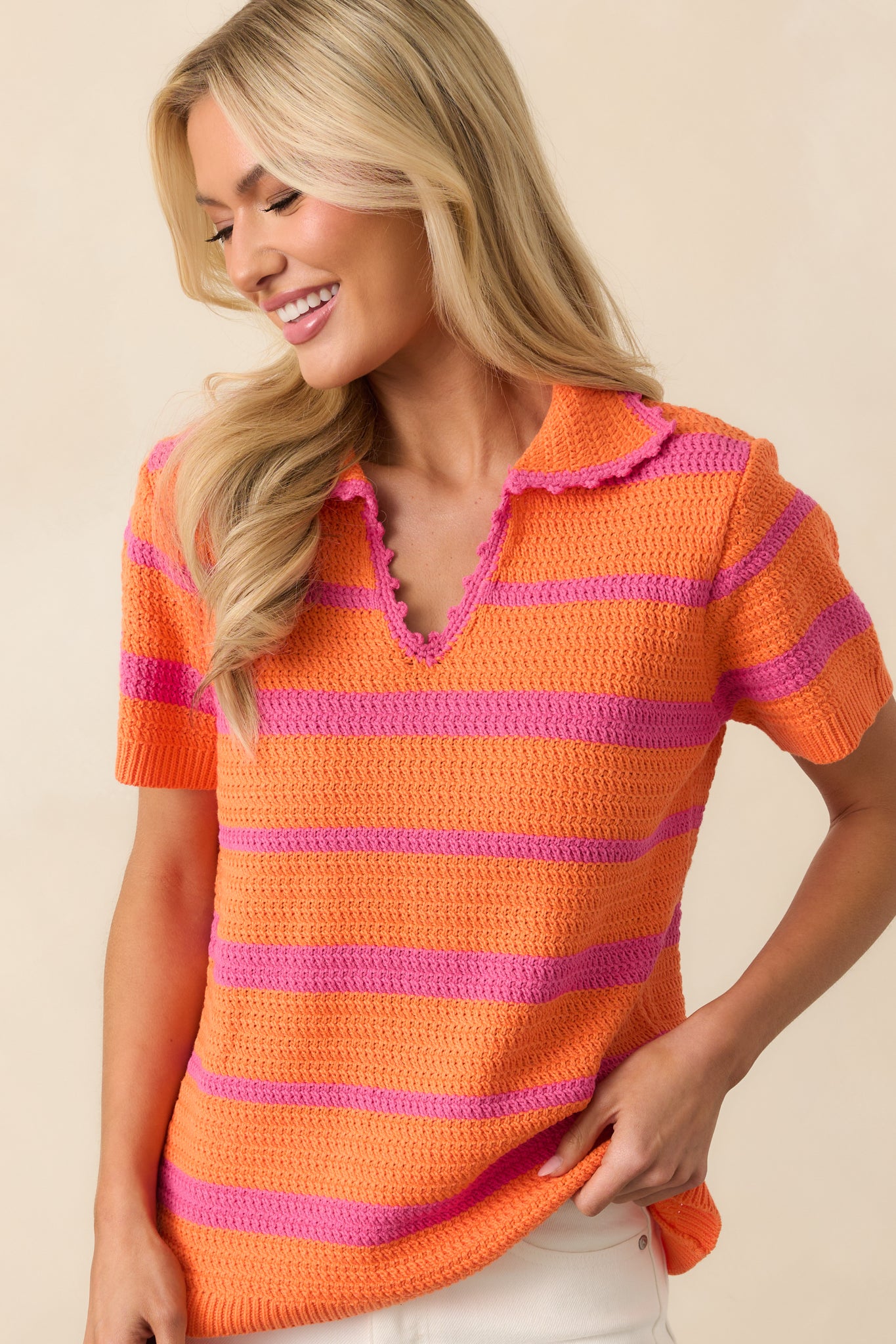 Cropped view highlighting the collared v-neckline and color contrast in the orange and pink stripes.