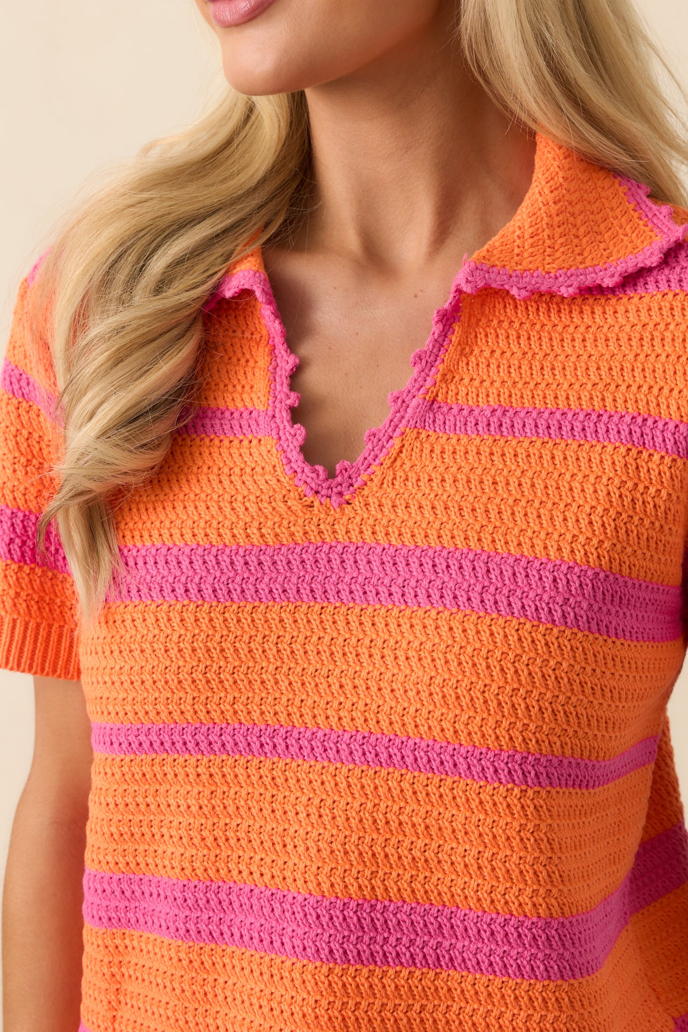 Detailed close-up of the knit fabric texture and bright orange and pink stripe pattern.