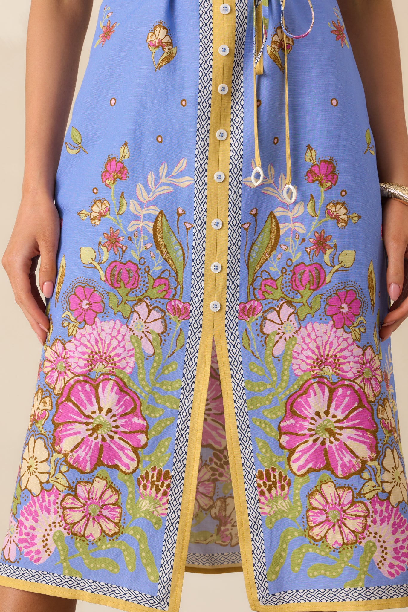 Close-up of the bottom hem of the blue midi dress, showing the front slit and clean stitched edge for a smooth, polished finish.