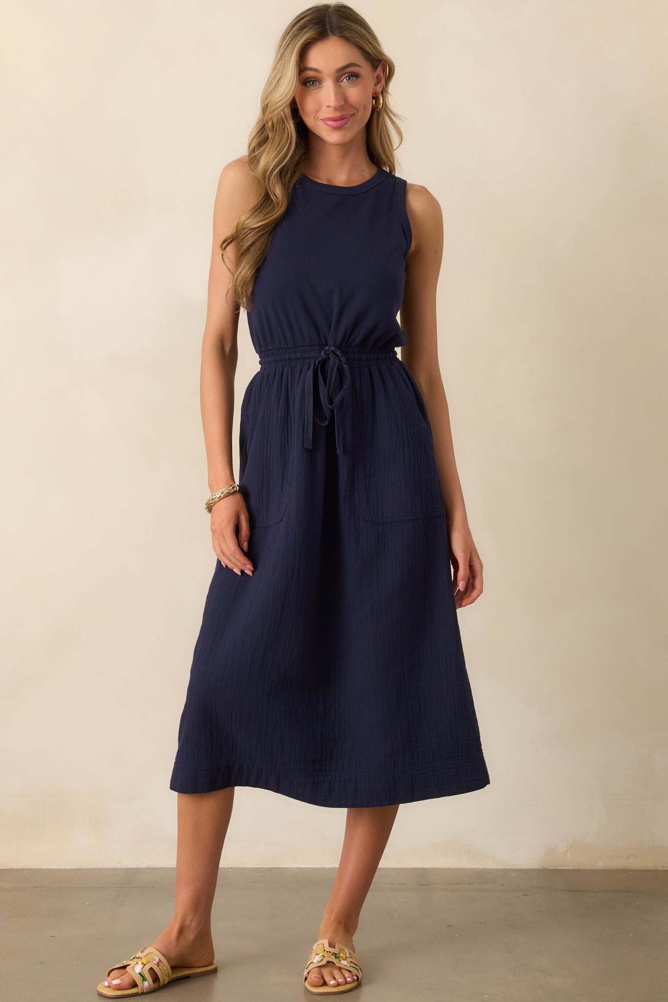 Full-length image highlighting the adjustable self-tie drawstring cinching the elastic waistband of the navy dress.