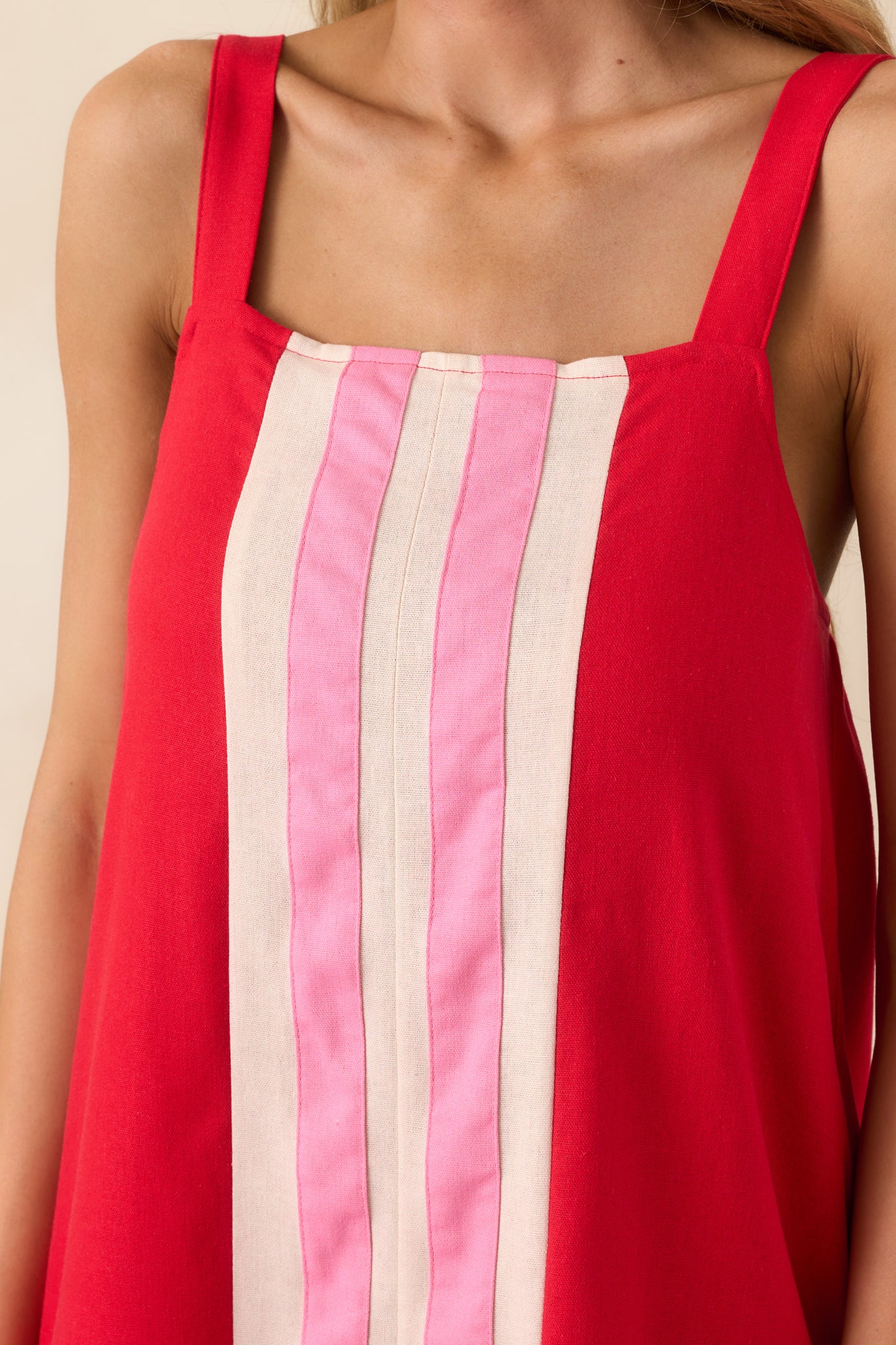 Close-up image capturing the square neckline, strap detail, and stitching along the color-blocked center stripe.