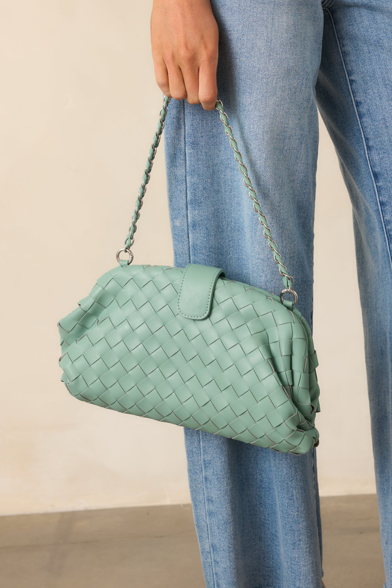 Close-up of the mint green handbag's braided shoulder strap and woven faux leather detailing, showcasing the mix of textures.