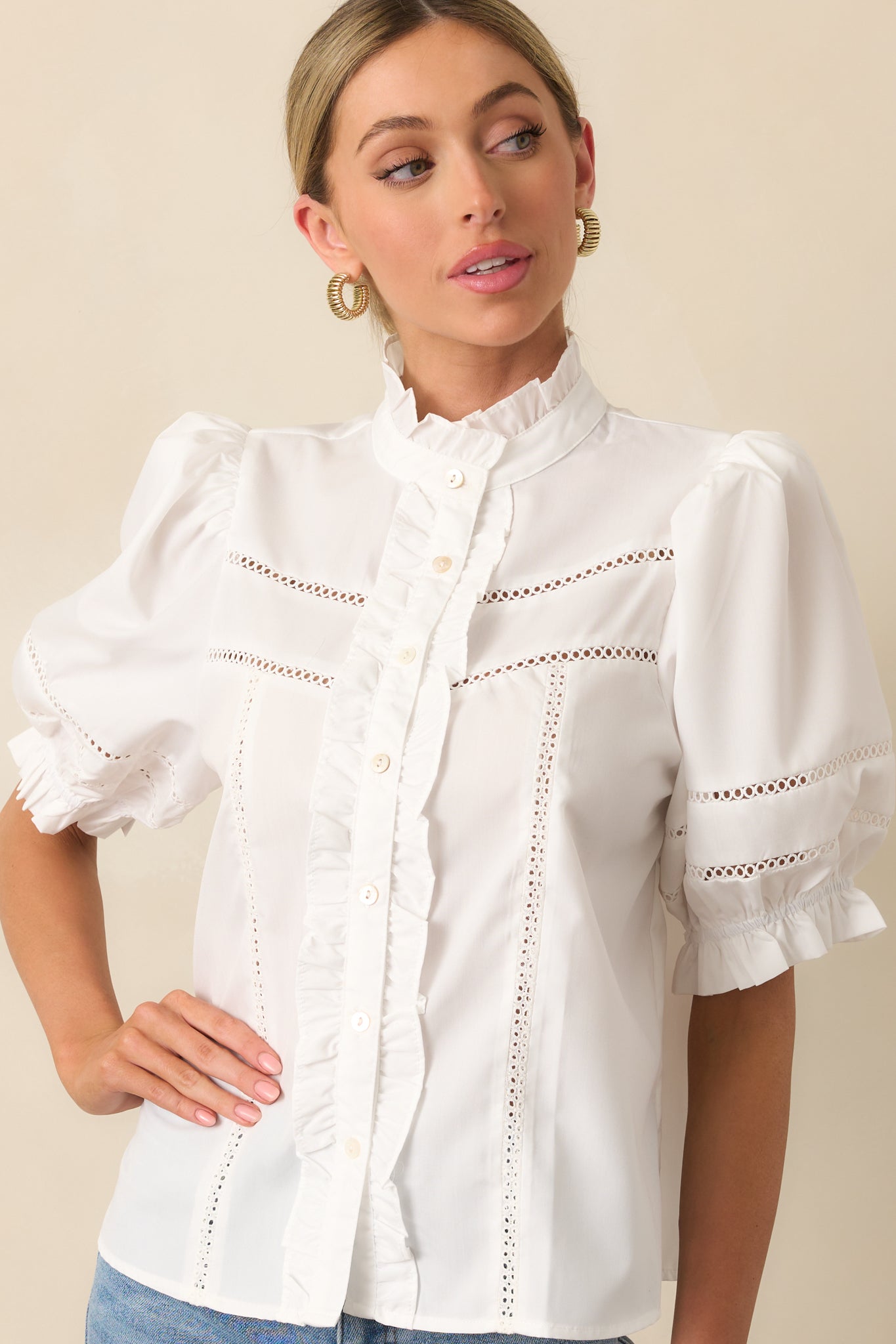 Close-up of neckline and button placket, showing ruffle trim and eyelet texture.