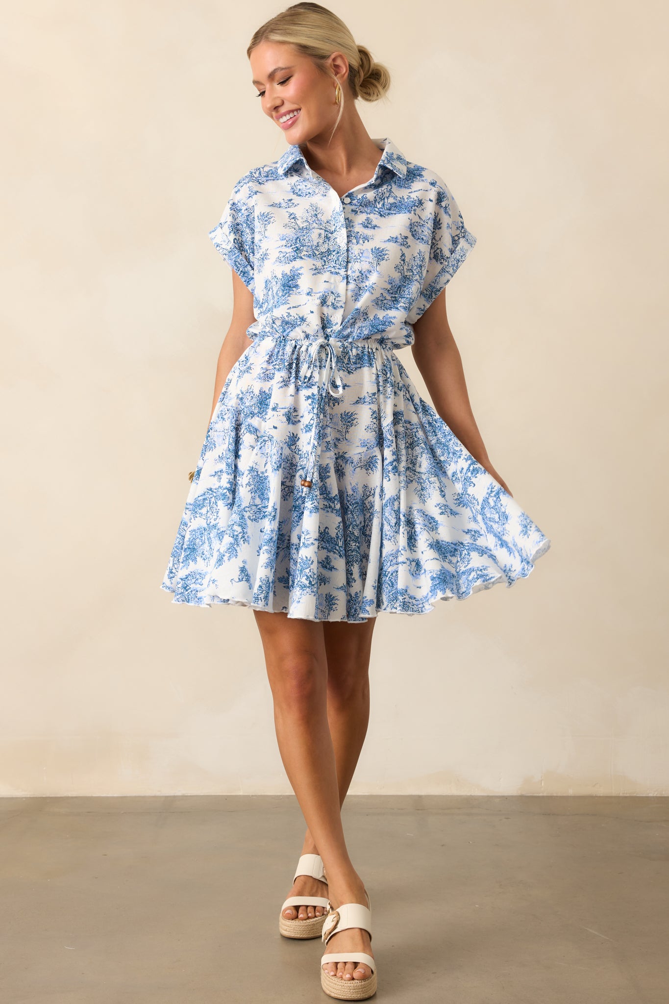 Mini dress with collared neckline, functional buttons down the front, and a flowy skirt shown in a full body front view.