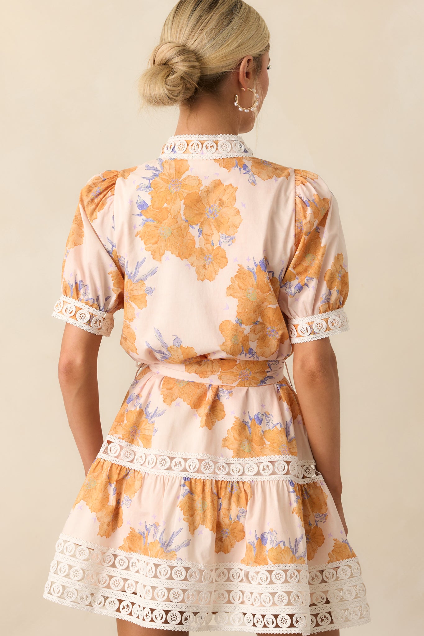 View from behind of the honey yellow mini dress showing the short puff sleeves and consistent lace trim