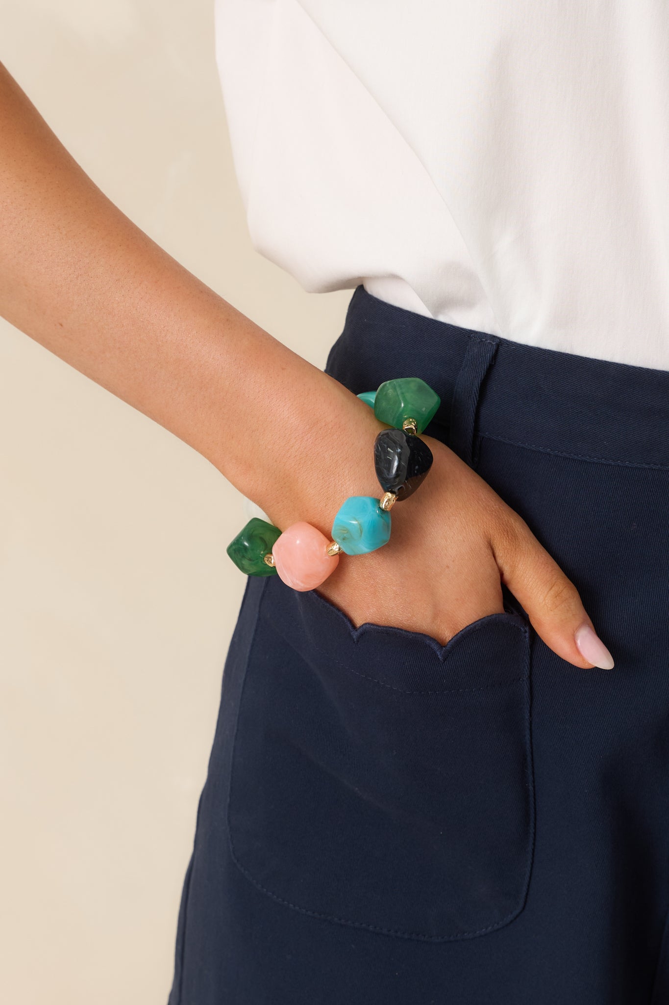 Close-in crop highlighting varied bead shapes, vibrant tones, and polished gold details.