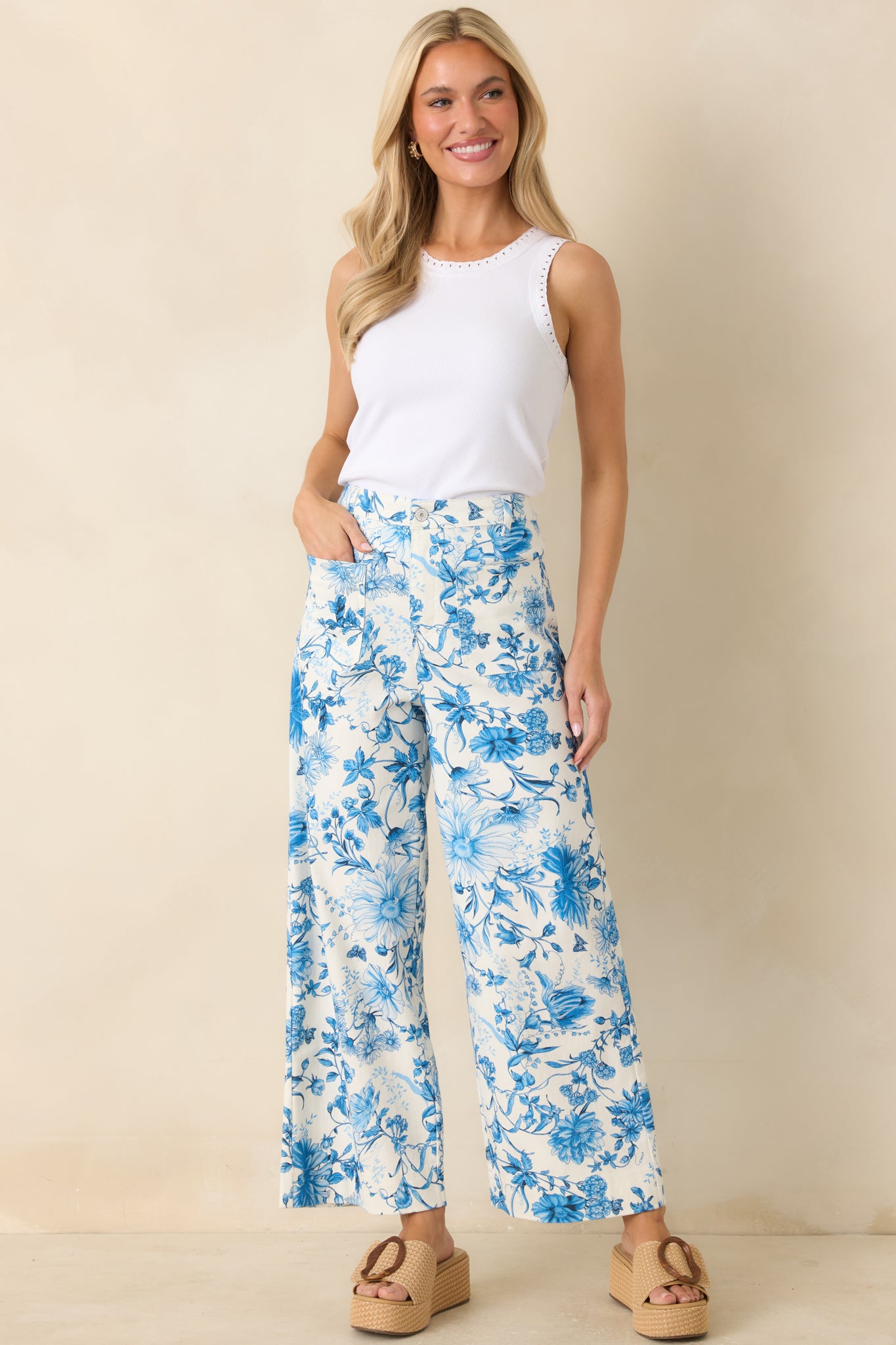 Blue floral cotton pants with high-rise waist, straight wide leg, and relaxed silhouette.