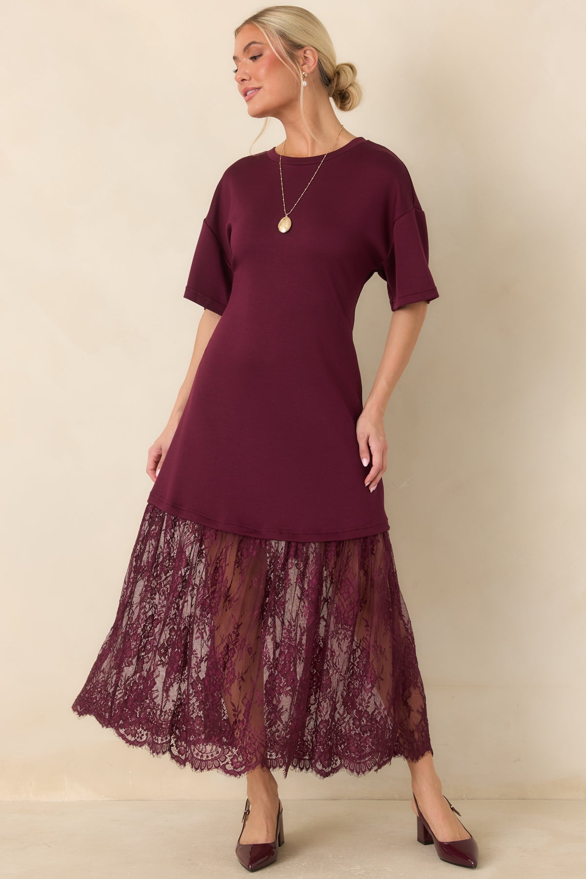 The plum dress combines a casual tee-style upper with a flowing lace overlay that finishes at a scalloped midi hem.