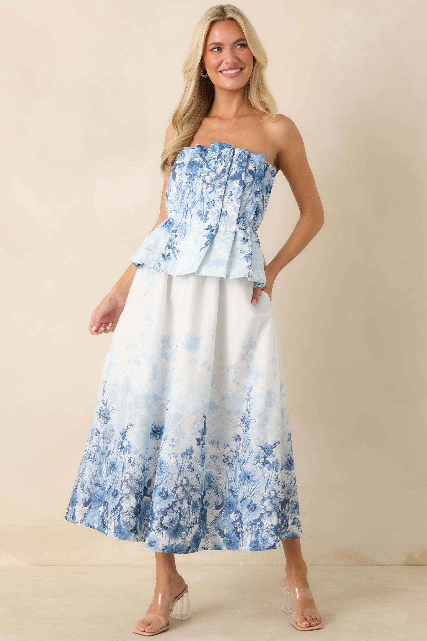 Cotton midi dress with blue floral print, structured bodice, and smocked back panel.