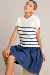 This dress features a crew neckline, a ribbed knitted bodice, horizontal stripes, and a solid flowy skirt.