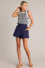 Angled full body view of these shorts feature that a high waisted design, a thick waistband, an elastic insert at the back of the waist, and functional hip pockets.