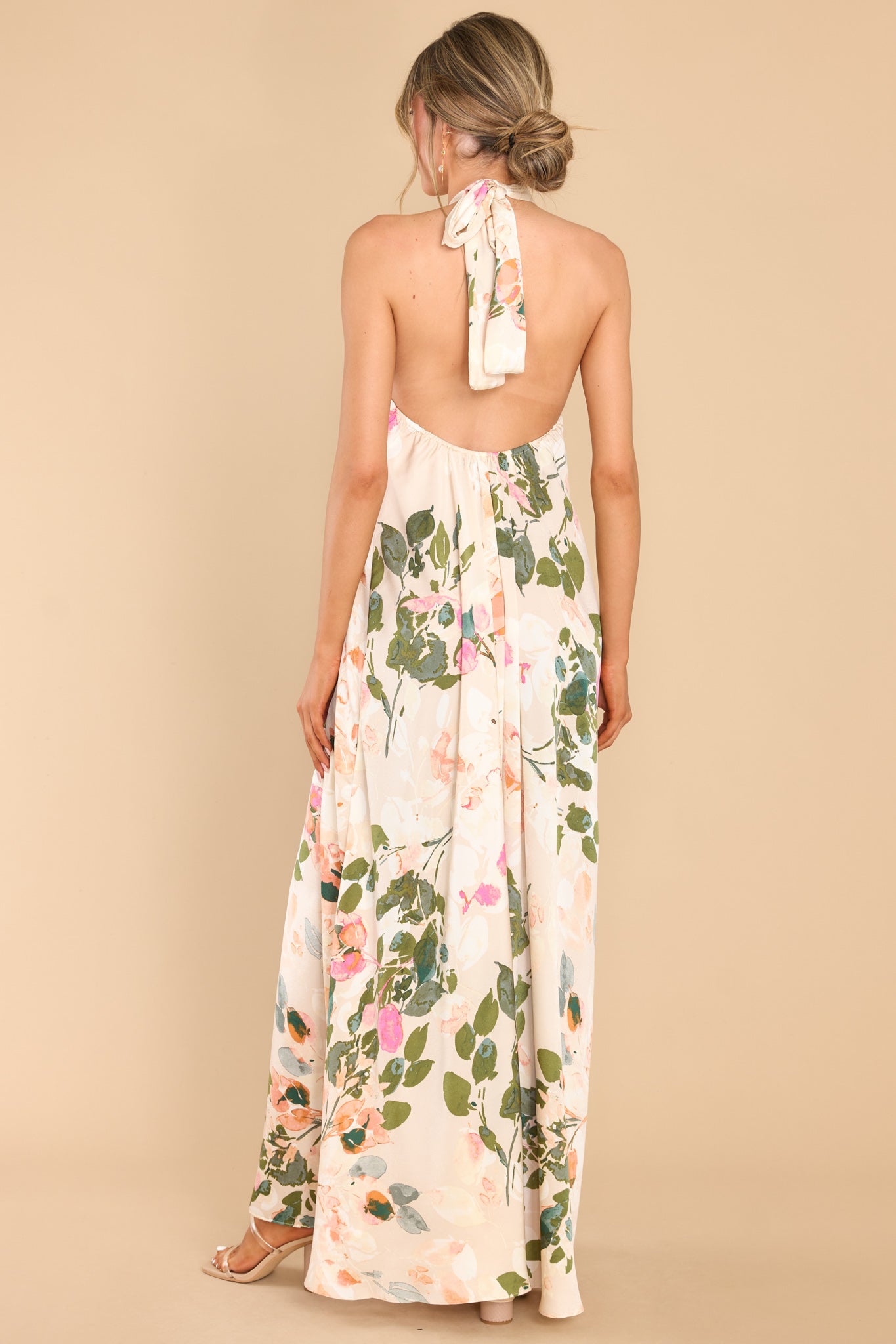 Back view of this dress that features a high neckline with keyhole cutouts and halter self tie around the neck, open back, elastic along lower back seam, and a flowy fit throughout.
