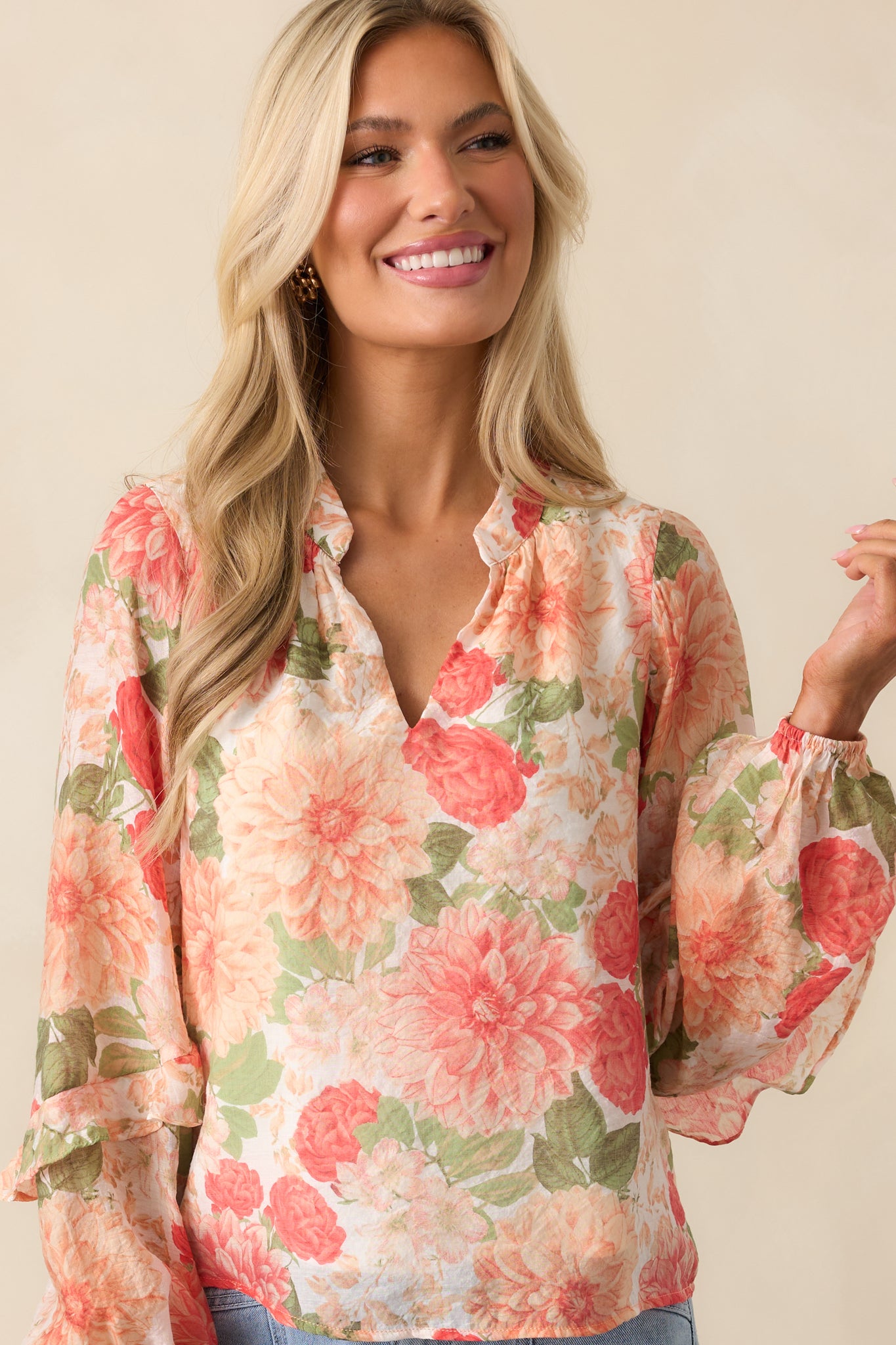 A tight crop of the long-sleeve blouse highlighting the visible white lining beneath the floral print.