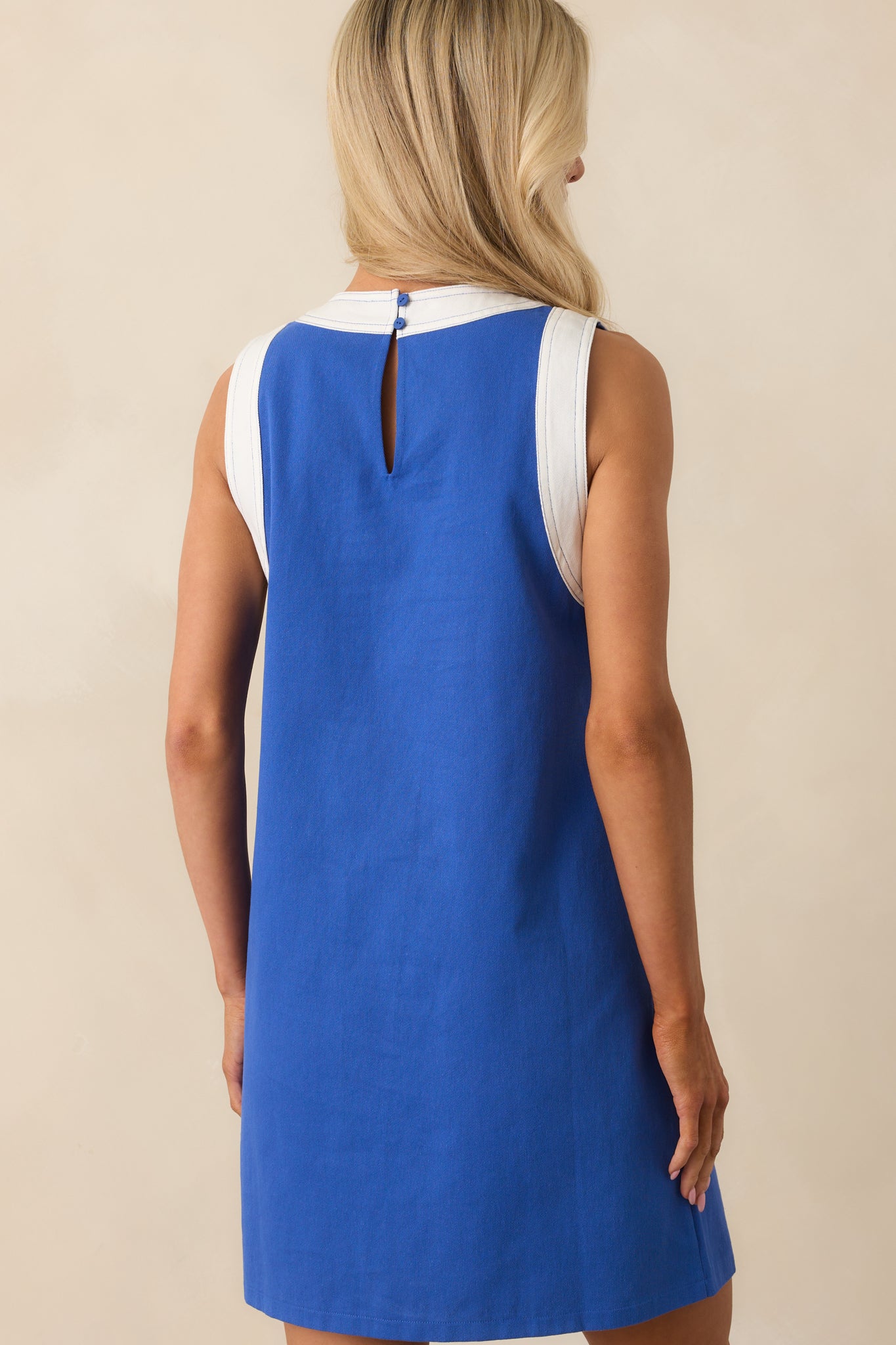 View from behind showing the sleeveless design and keyhole button closure at the upper back with white trim accents.