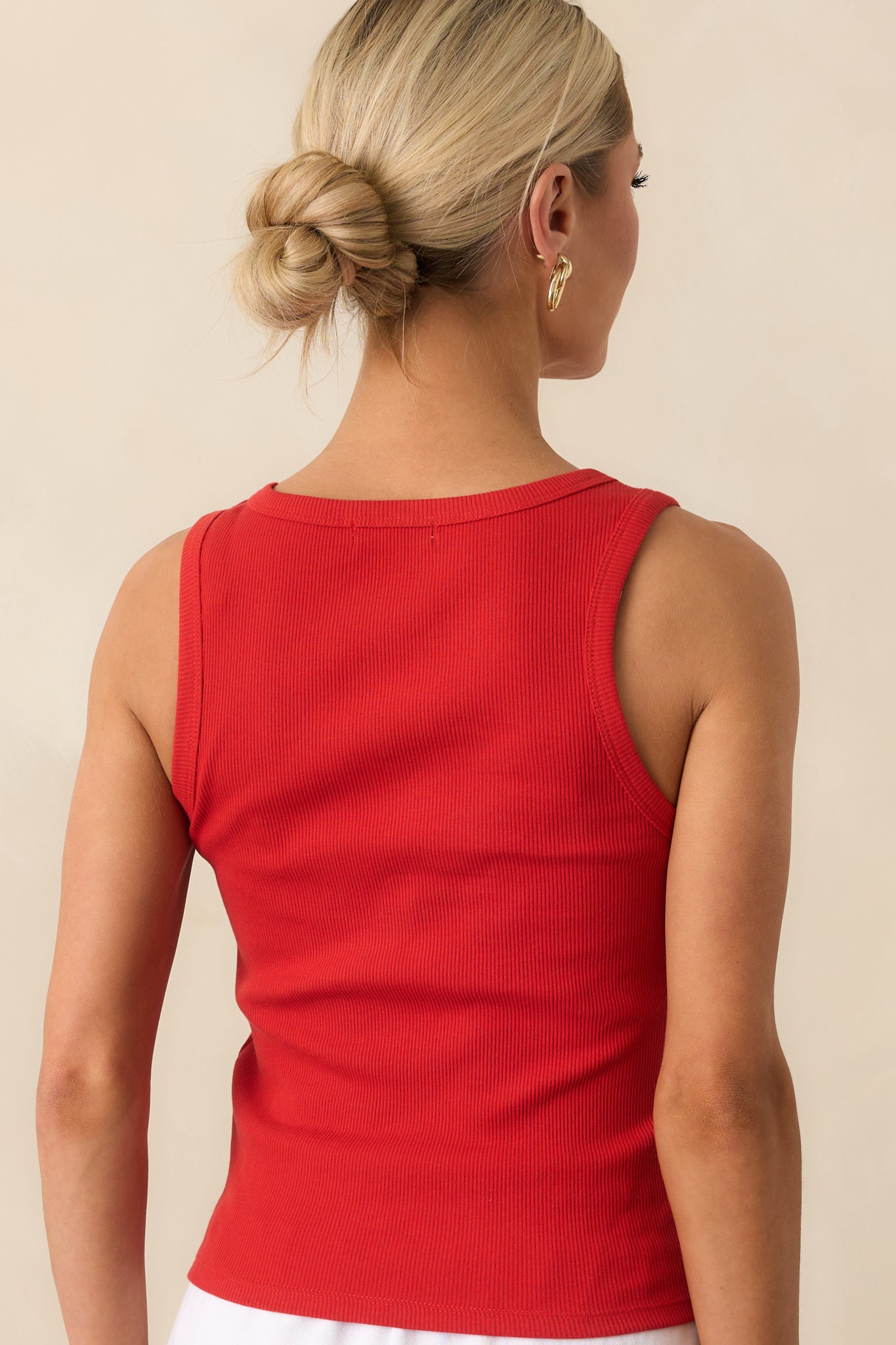 A view from behind showing the fitted back and sleeveless tank design of the red rib knit top.